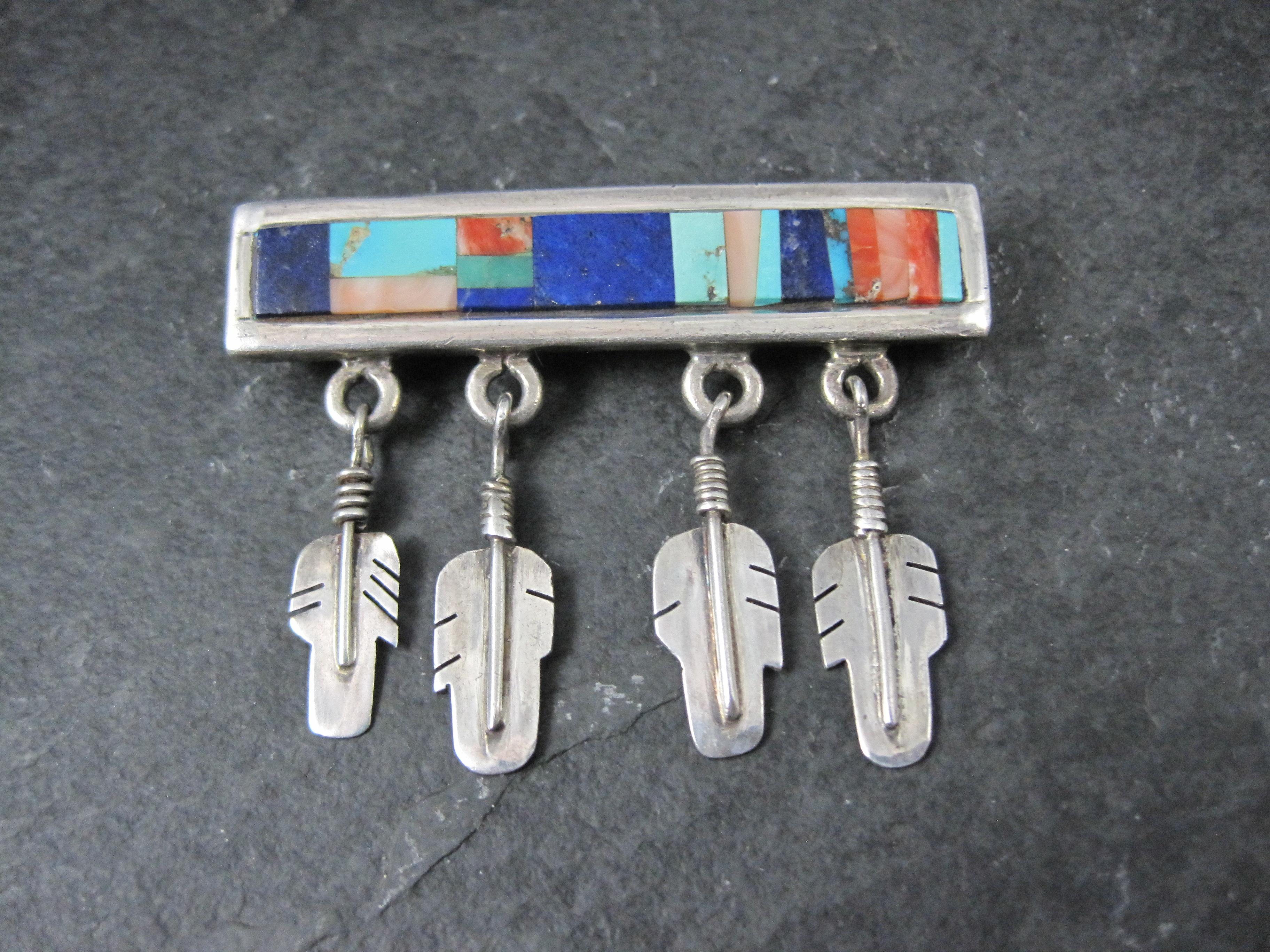 Questa splendida spilla del sud-ovest è in argento sterling con intarsi in turchese, lapislazzuli, corallo e ostrica spinosa.

Misure: 2 1/8 per 1 5/8 pollici

Marchi: AB, Sterling