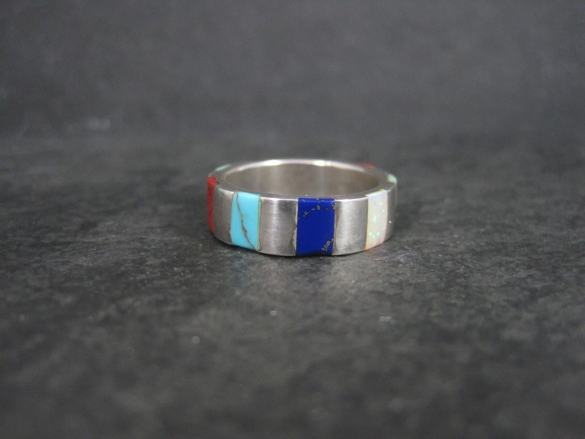 This beautiful Southwestern Inlay ring is sterling silver.
It features gaspeite, sugilite, turquoise, coral, opal and lapis lazuli stones.

Measurements: 6mm wide
Size: Sizes as a 7 1/4 but fits more like a large 7 due to the width and thickness of