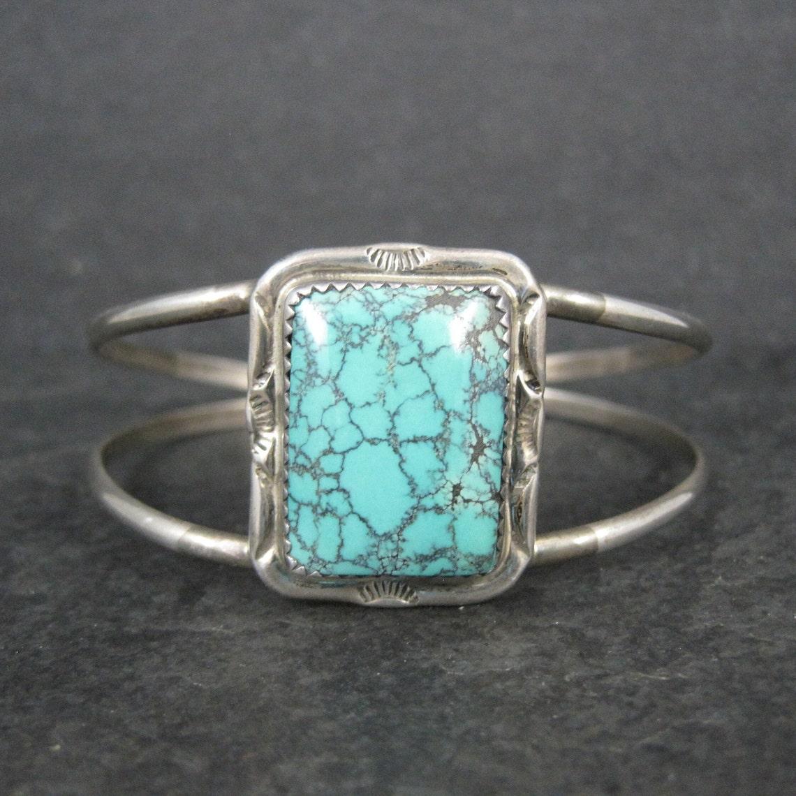 This beautiful vintage, Southwestern cuff bracelet is sterling silver with a 16x21mm turquoise gemstones.

The face of this cuff bracelet is 1 1/16 inches wide.
It has an inner circumference of 6 inches including the 1 inch gap. It is