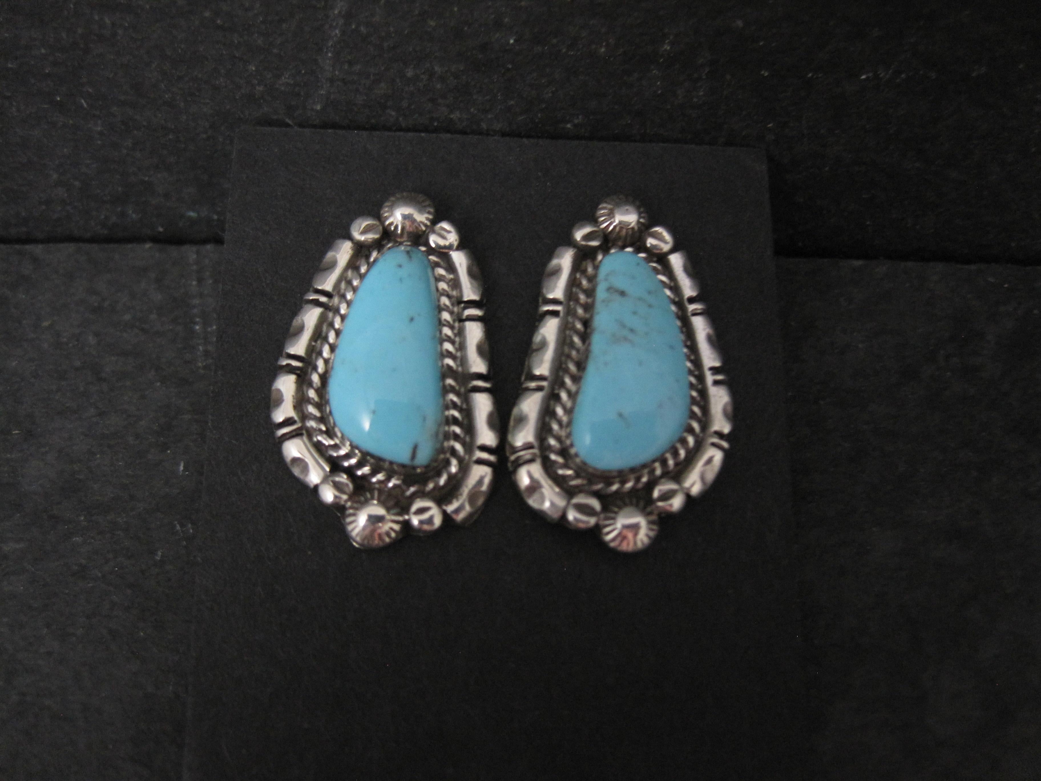These gorgeous earrings are sterling silver with genuine turquoise gemstones.
They are the creation of Navajo silversmith Anne Spencer for Running Bear Shop.

Measurements: 5/8 by 1 inch
Weight: 8.6 grams

Condition: New