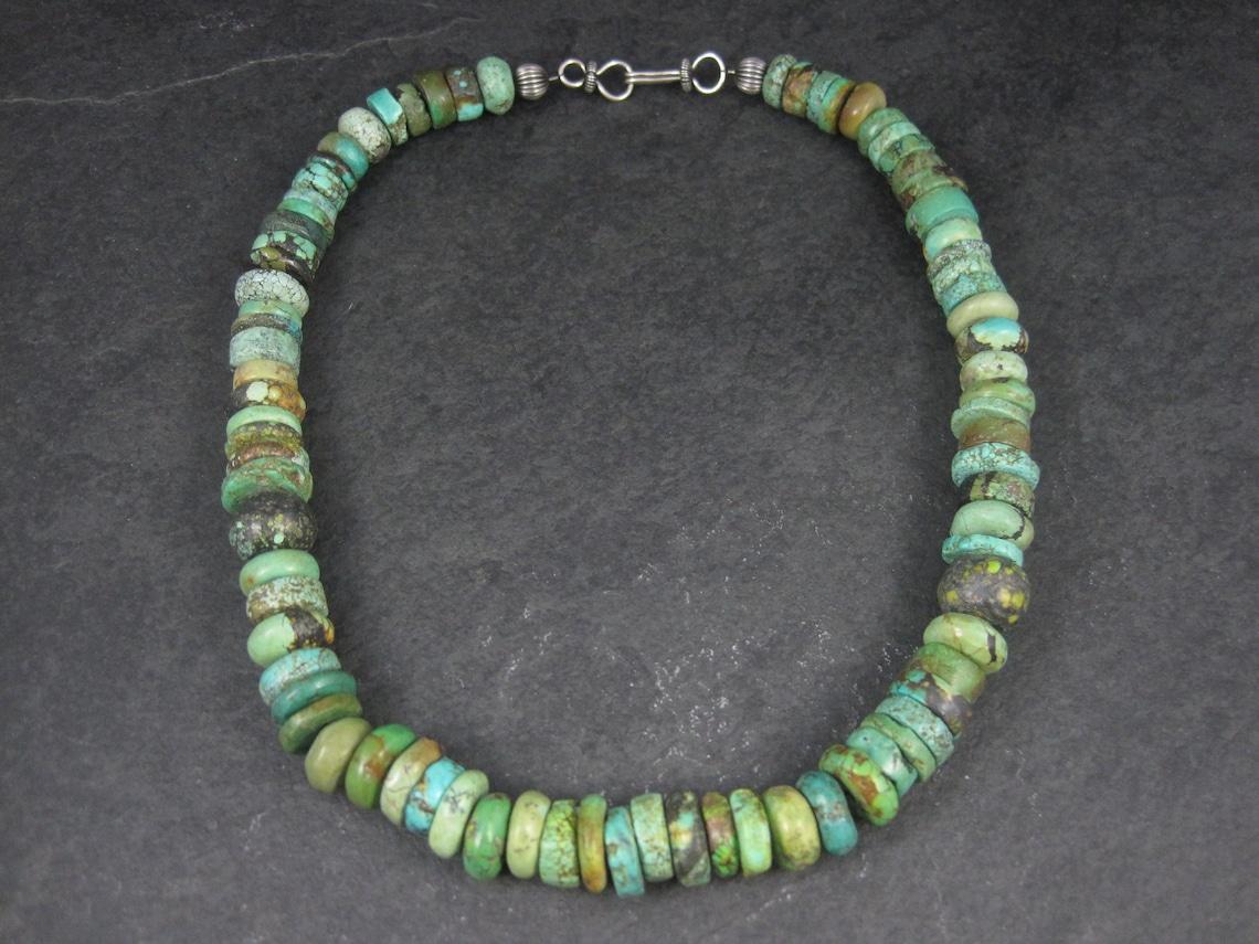 This gorgeous Southwestern necklace features genuine turquoise disk beads, sterling silver beads and a sterling silver hook style clasp.

Measurements: 14mm wide, 18 inches from end to end

Weight: 101.6 grams

Condition: Excellent