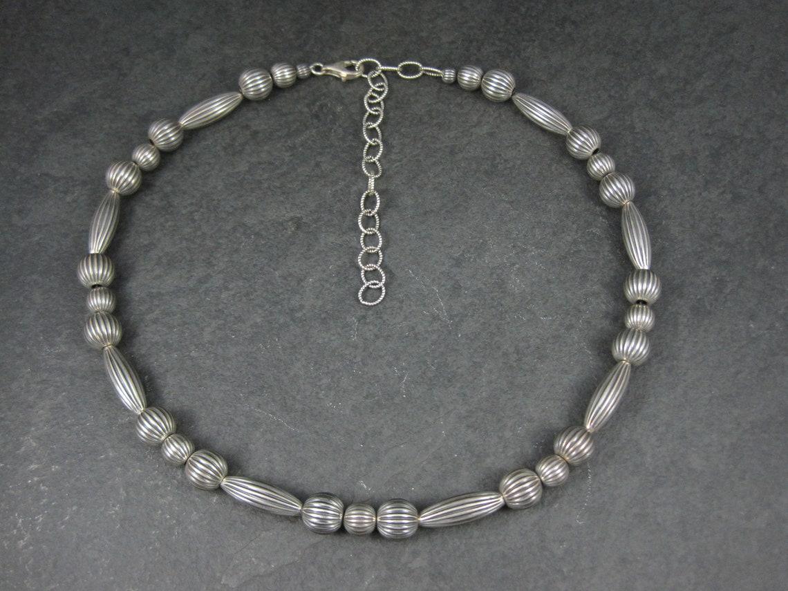 This beautiful Southwestern estate necklace is sterling silver.

Measurements: 10mm at its widest point - adjustable from 16 to 20.5 Inches

Marks: 925

Condition: Excellent