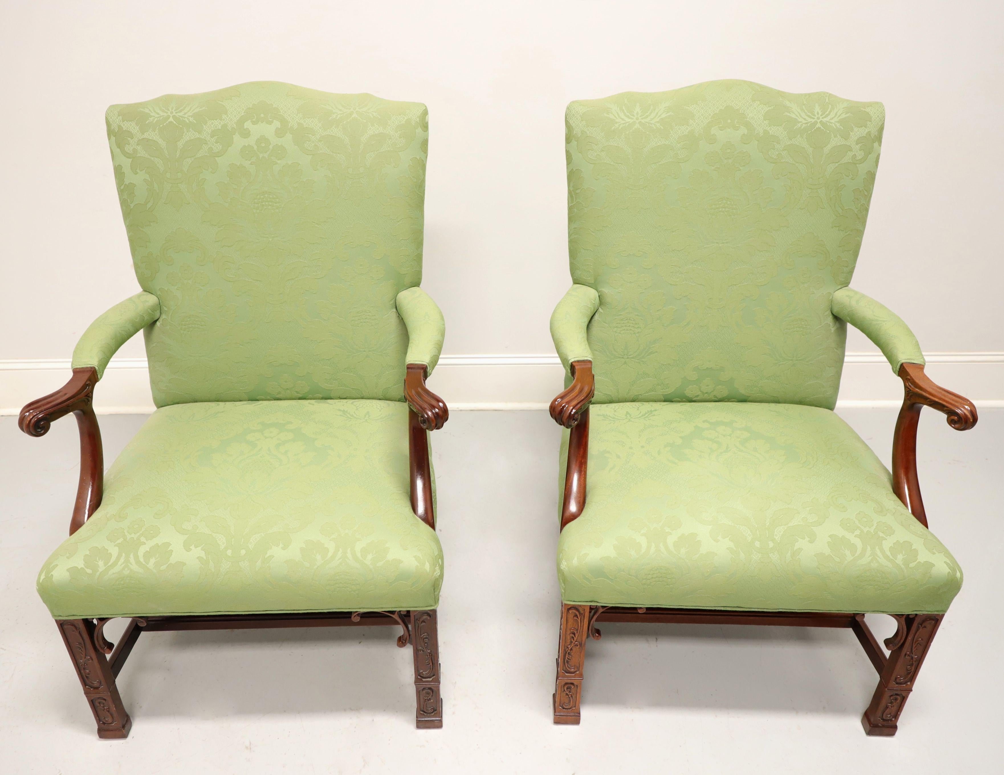 A pair of Chippendale style upholstered armchairs by Southwood, their Gainsborough. Mahogany frame, a light green color brocade fabric upholstery, upholstered scroll arms, decorative fretwork carved straight front legs, stretcher base, and capped