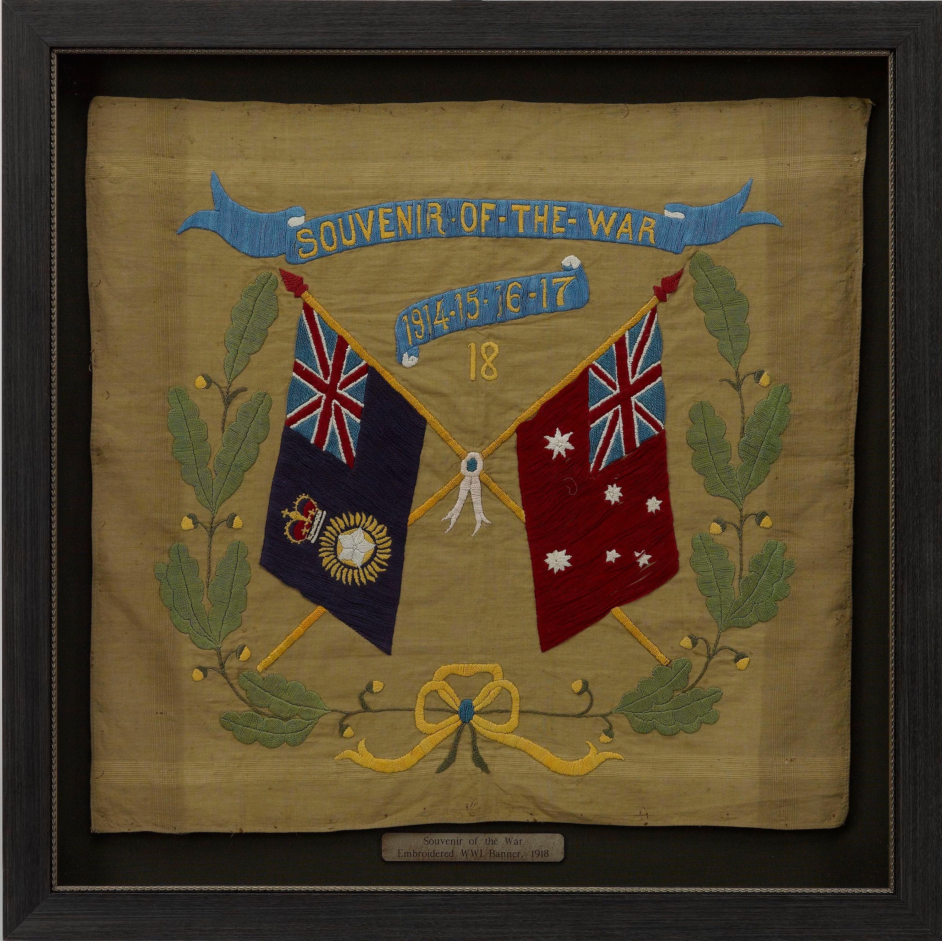 Es handelt sich um ein wunderschönes Textilbanner aus dem Ersten Weltkrieg, datiert auf das Jahr 1918. Das quadratische, hellbraune Baumwolltuch ist mit zwei gekreuzten Flaggen bestickt, der Royal Indian Marine Ensign und der Australian Civil