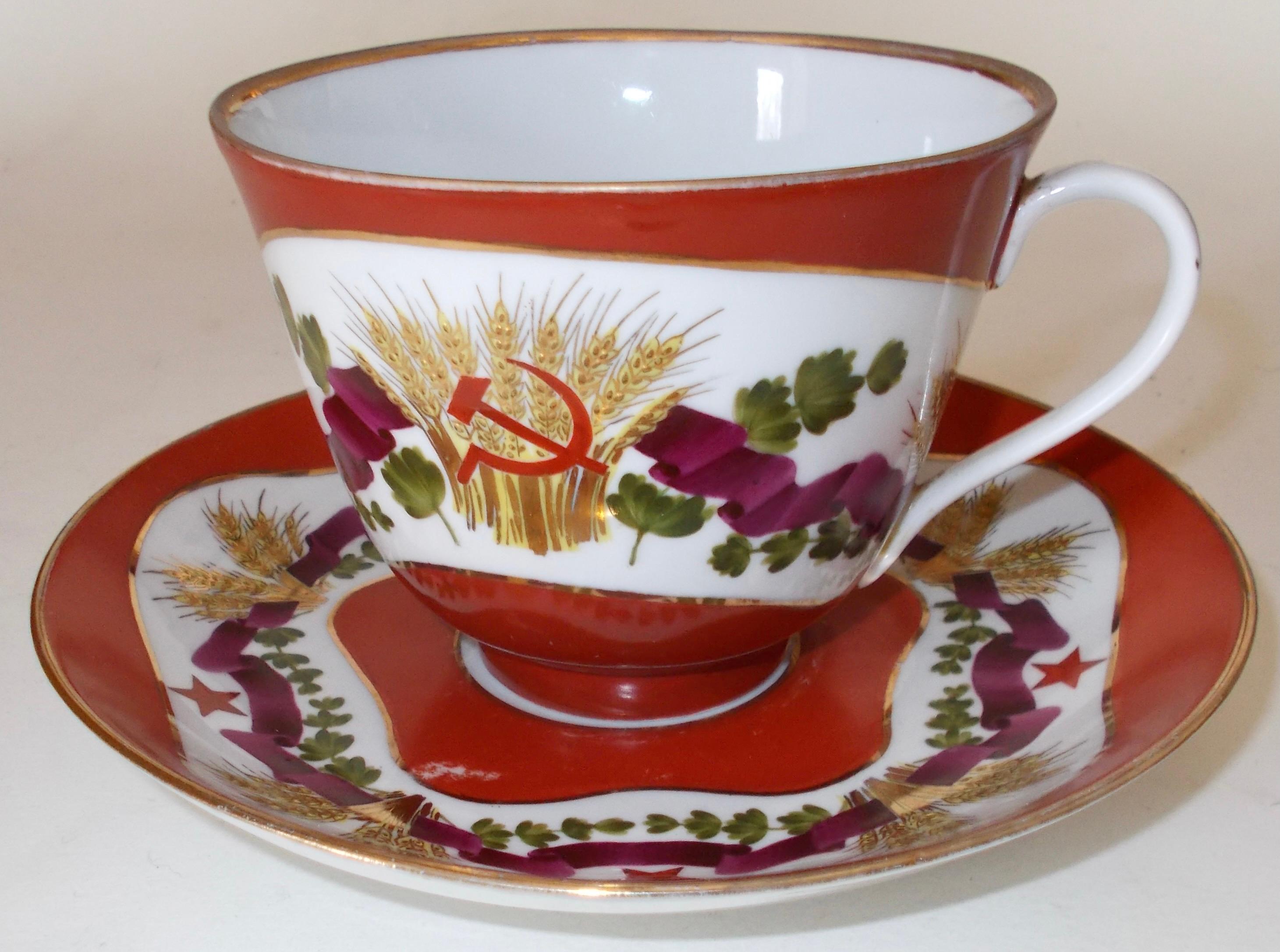 Extra large Soviet Russian porcelain cup and saucer. Hand painted with gold sheafs of wheat, hammer and sickles and red stars. Fully signed on the bottom both underglaze with the Lomonosov late 40's early 50's mark and individually hand numbered.