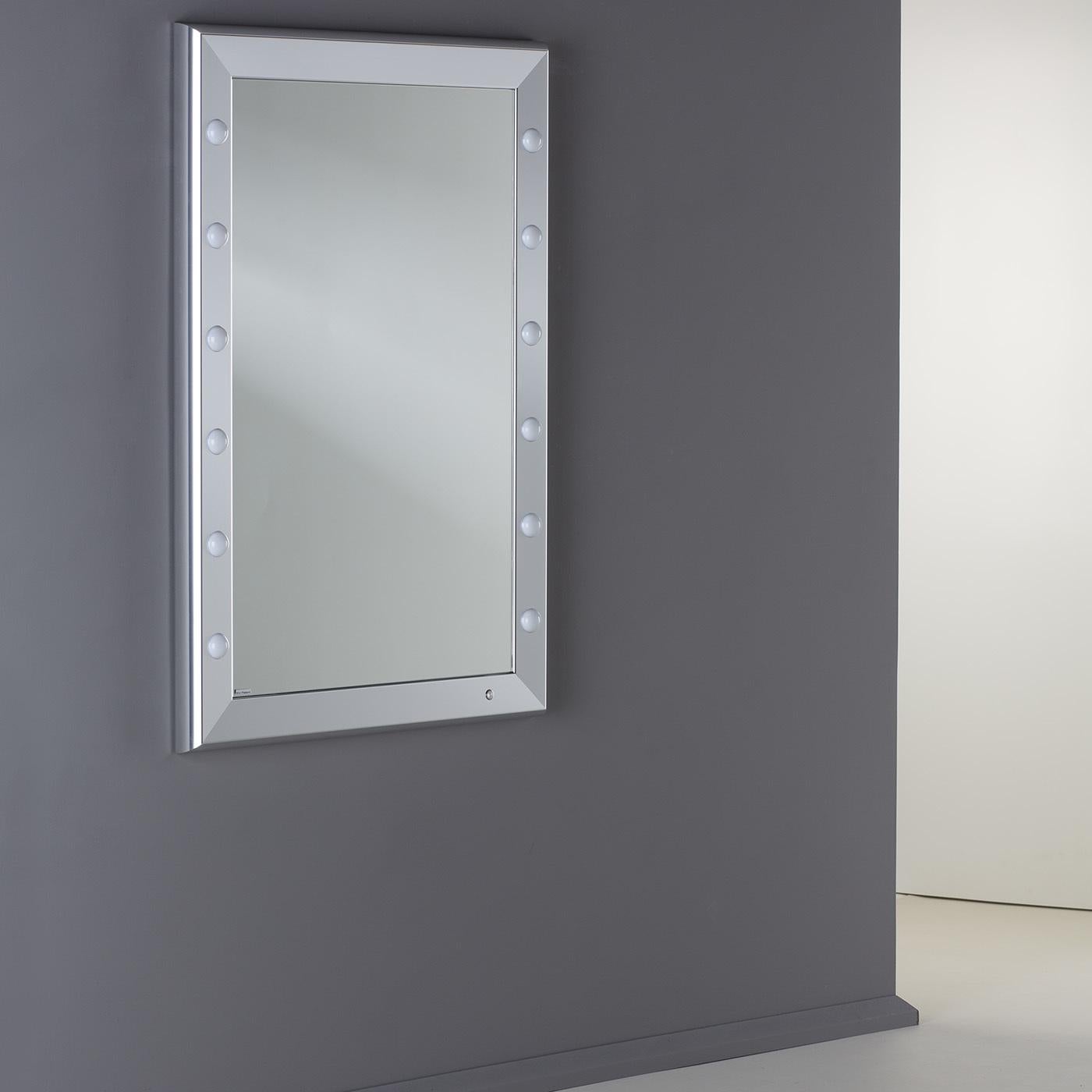 Far from being a mere decorative piece, this classic backstage-style lighted mirror is equipped with high-tech features that make it a must-have accent for a bedroom or walk-in closet. Part of the SP line, the polished silver anodized aluminum frame