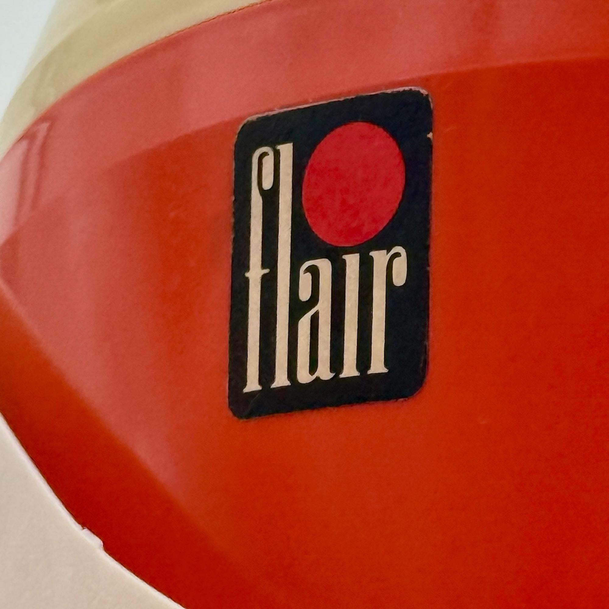 Ravviva il tuo spazio con questo originale sgabello arancione anni '70 prodotto da Flair, progettato per organizzare con stile gli attrezzi da cucito. La sua forma compatta e giocosa è dotata di una pratica maniglia per il trasporto, di un