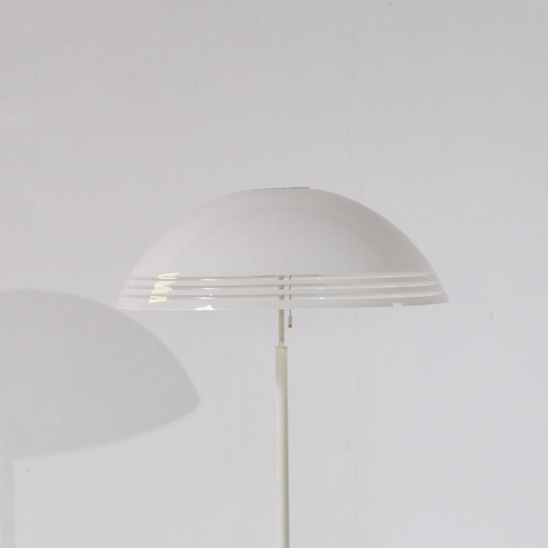 A 1970s Space Age floor lamp with a large 'mushroom' shade. Presumably from the Netherlands or Germany. The shade is acrylic and the frame and foot are metal. The white lamp can be turned on and off with a subtle string and has two standard E27