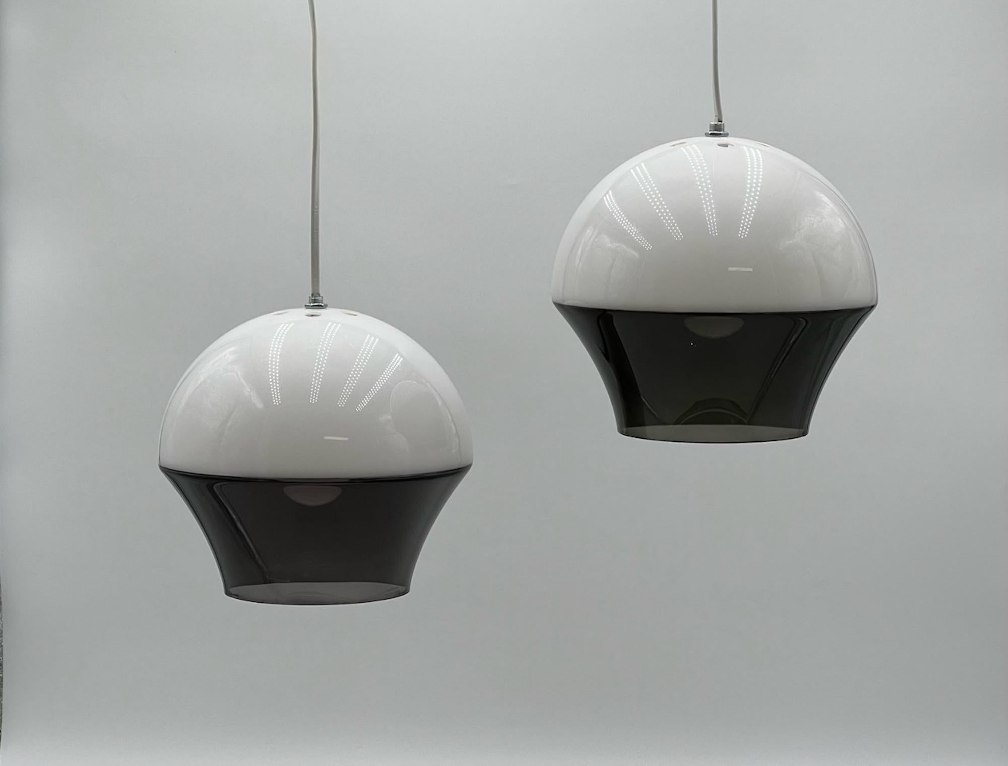 Pair of space age pendant lamps made of two-color acrylic material in Italy in the 70s.

The lampshade is made of a white half globe and a grey translucent light diffuser. The overall shape reminds a flying saucer, giving this set a powerful and