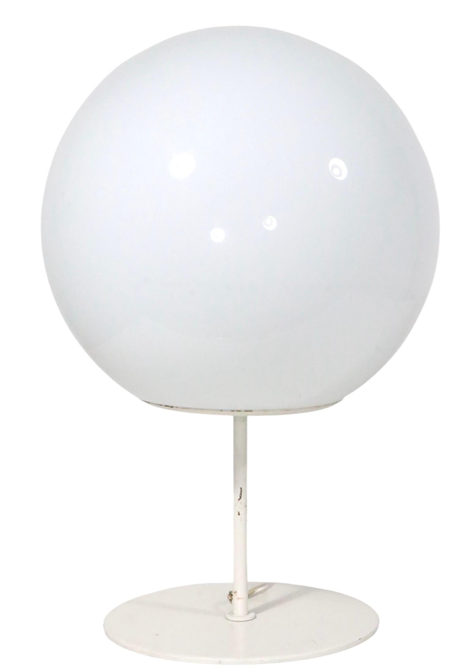 Cool Futurist style, Space Age table lamp attributed ton Robert Sonneman for Sonnemen Lighting, circa 1960's. The lamp features a white glass ball shade, mounted to the heavy metal base. This example is in very good, clean, working, ready to use