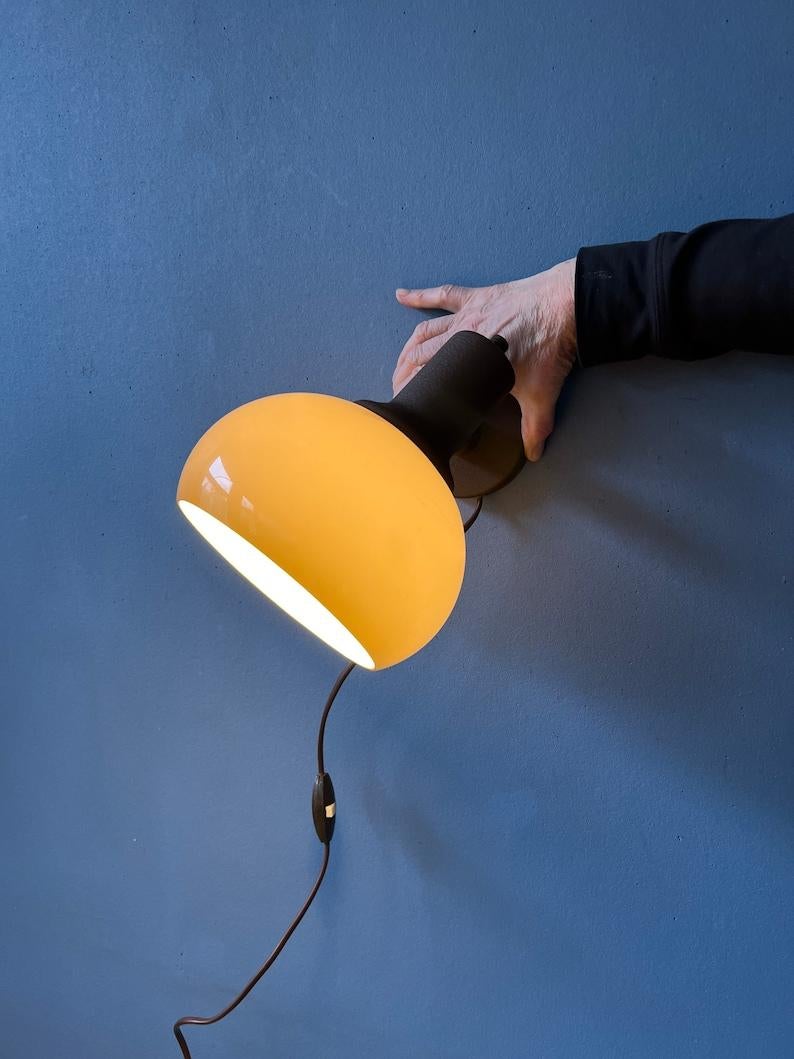 Space age mushroom wall lamp by Herda. The small arm of the shade can be turned in different directions. The lamp requires one E27 lightbulb and currently has an EU-plug.

Additional information:
Materials: Metal, plastic
Period: 1970s
Dimensions: ø