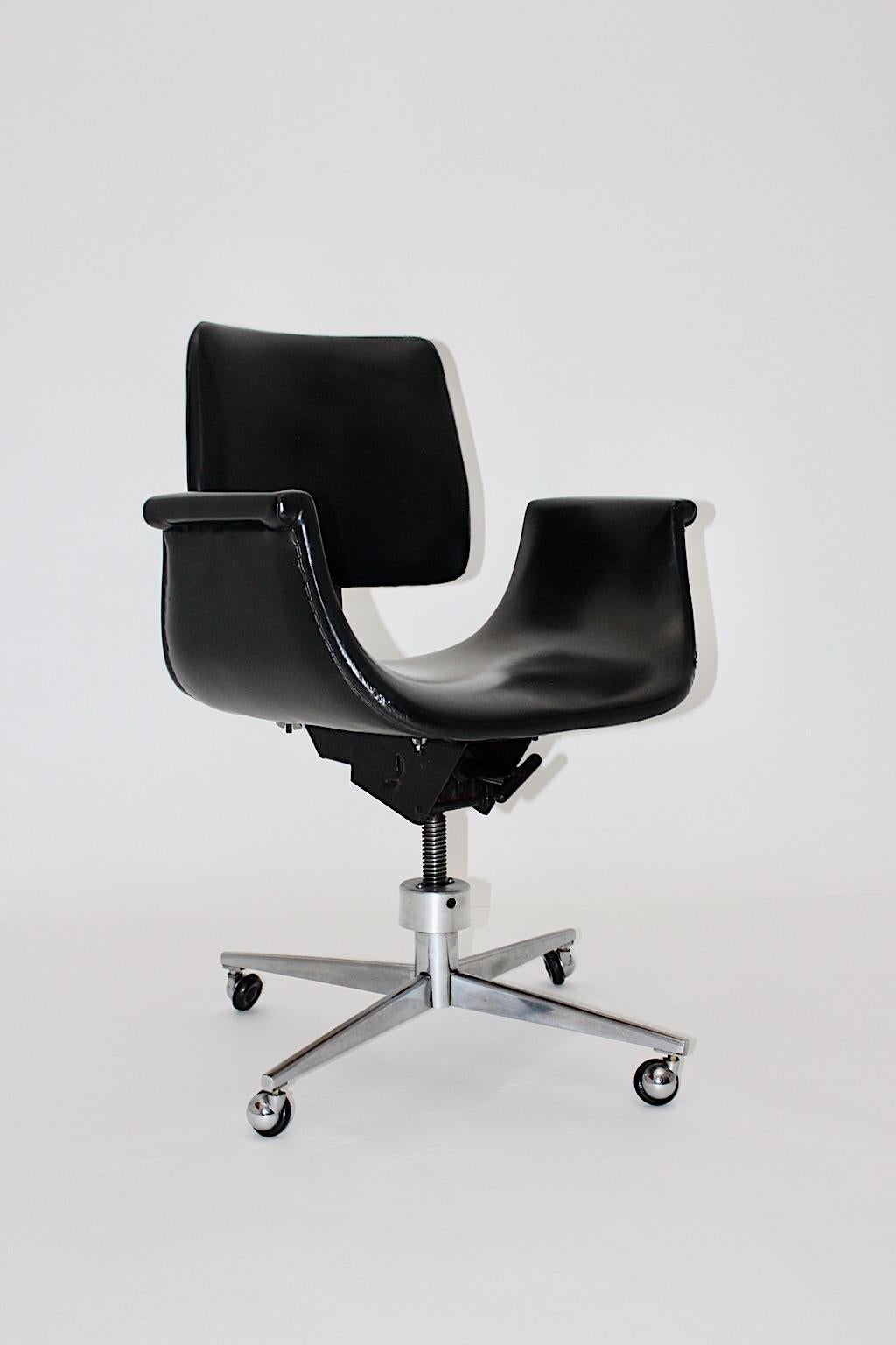 Space Age vintage desk chair from faux leather and metal tulip - like 1960s.
A wonderful office chair or desk chair, this model from the 1960s with a metal base with four wheels and a seat shell covered with black faux leather.
This sleek office