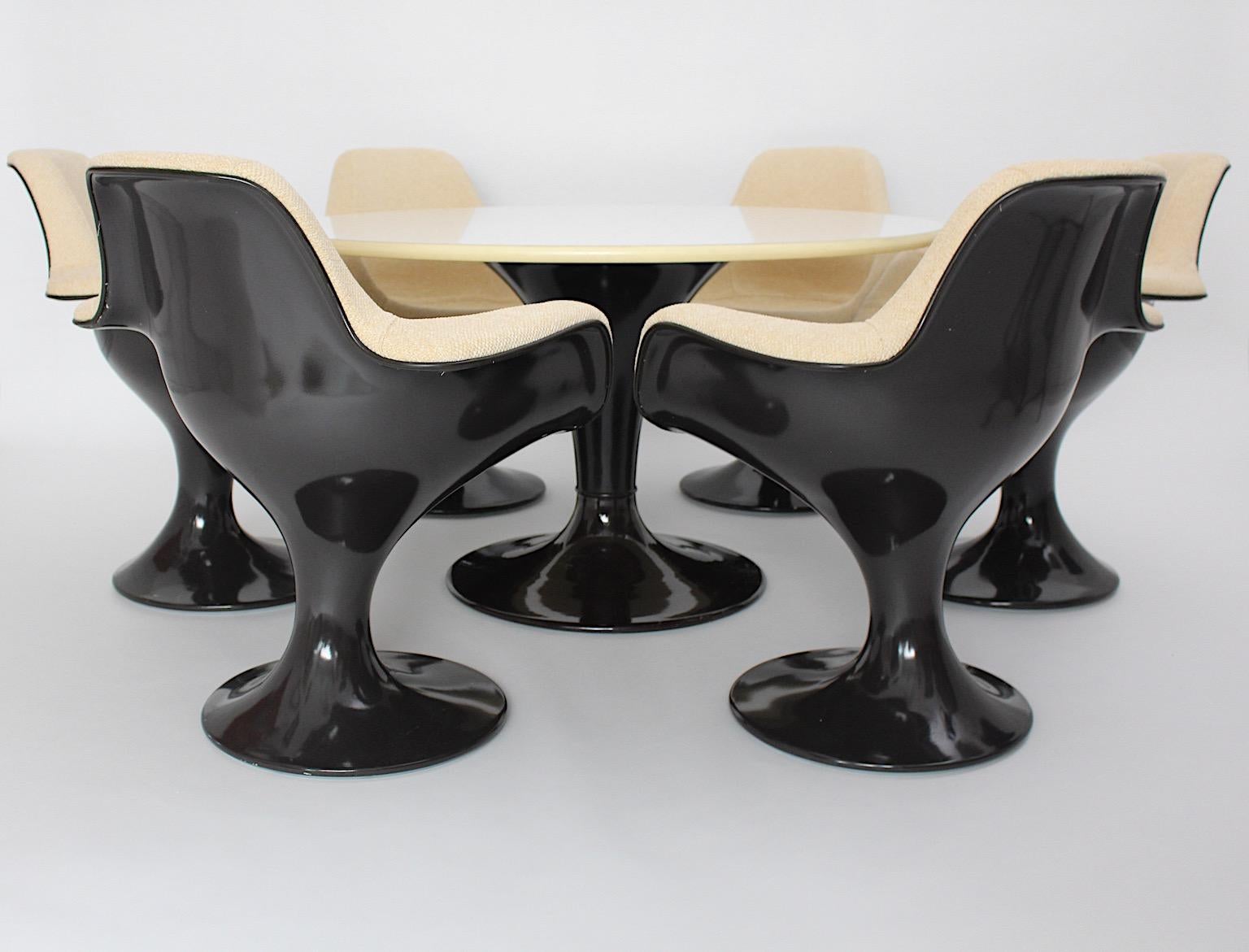 Space Age vintage dining room set from plastic in a chocolate brown tone reupholstered with light brown textile fabric. The dining room set consists of one dining table and six dining chairs.
The dining table shows a brown plastic covered metal base