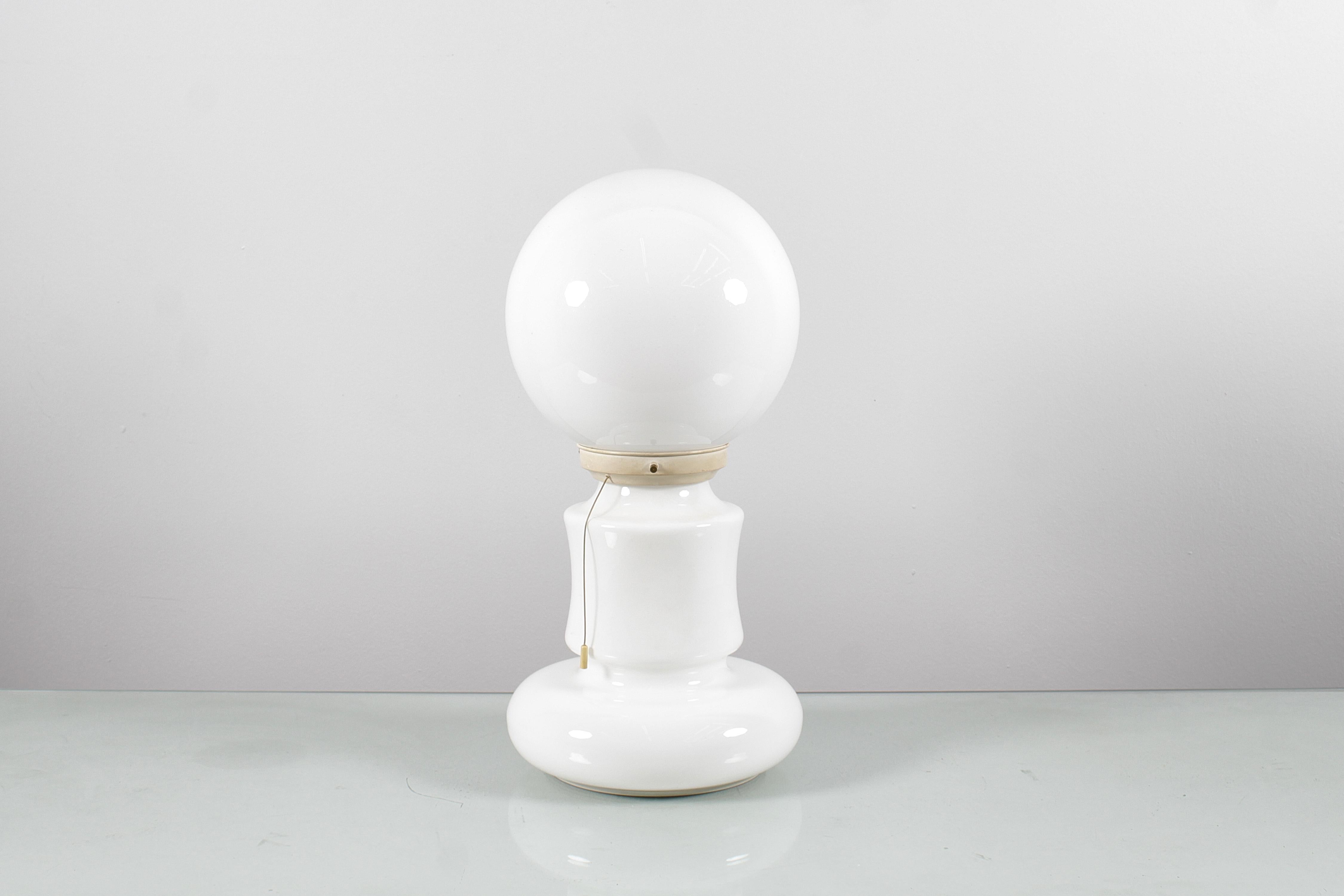 Beautiful example of a Space Age table lamp in white Murano glass, in the shape of a skittle, with an upper globe. The upper light is dominant, if it is on, the lower one can be turned on or off using a rope switch. Attributed to Carlo Nason for