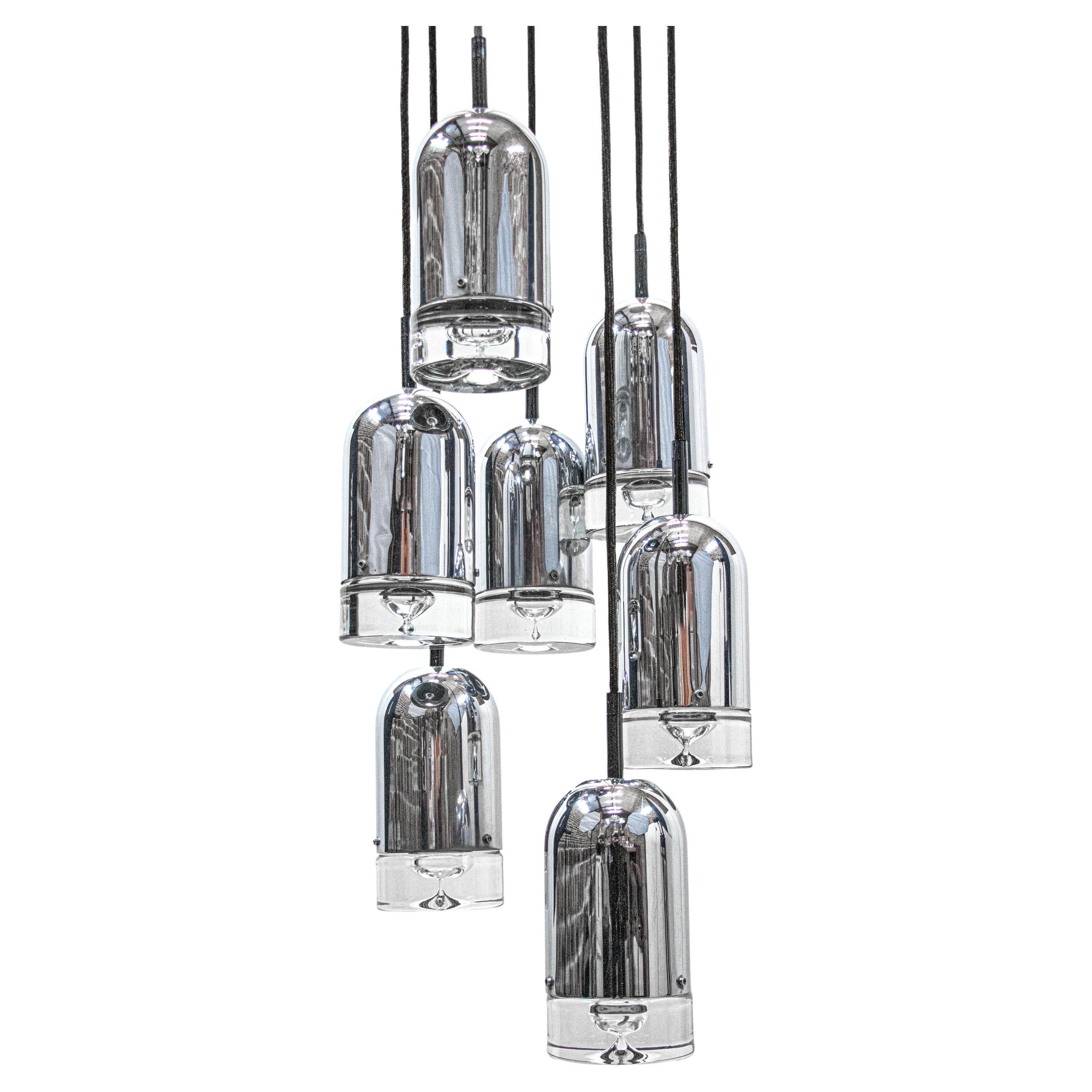 Exceptional cascading space age chandelier with seven chrome and crystal pendants. Hanging glass resembles tear drops. Heavy duty. Has 7 sockets. Height adjustable. In very good condition. Gives beautiful light. Amazing mid century design. Gem from