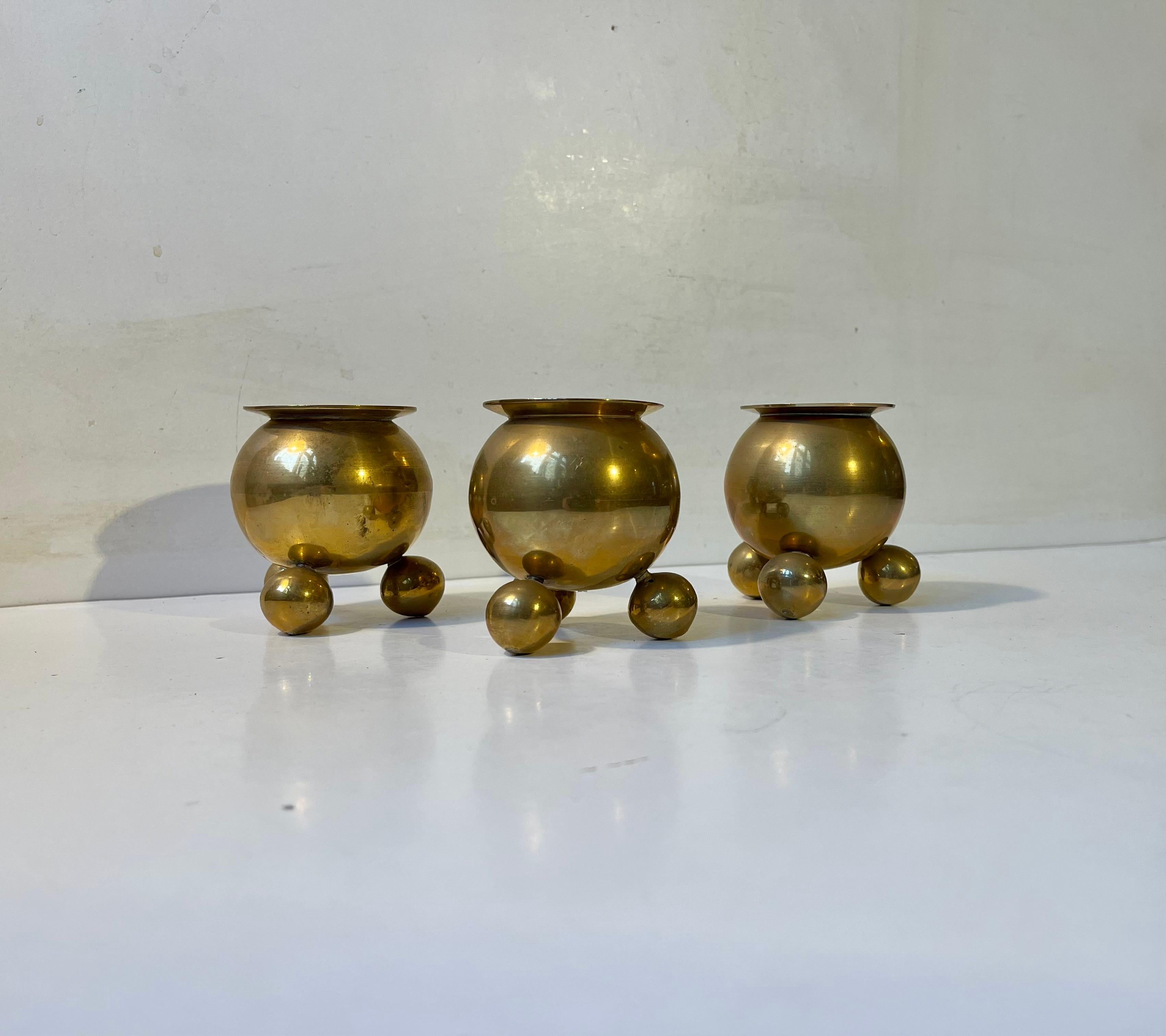 Atomic space age candleholders in the shape of cauldrons. They are made from brass during the 1950s Scandinavia and feature patina from the spand of time. They are to be fitted with regular sized candles. The Candles in the photos are not included.