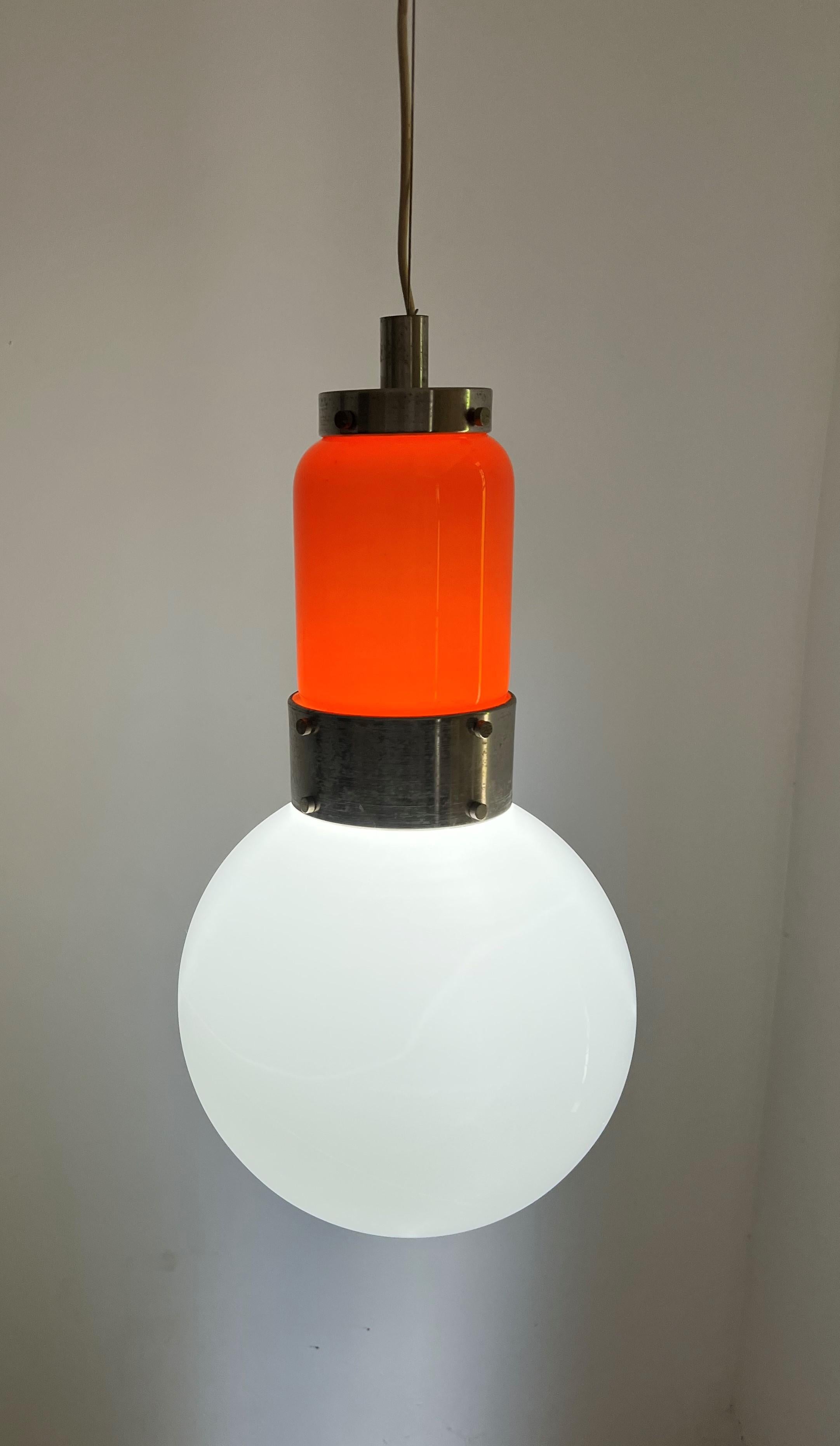 Lampe suspendue de l'ère spatiale par Carlo Nason pour NO AGE, vers 1970.
Cette lampe se compose de 2 pièces distinctes en verre opalin orange et blanc.
La lampe contient une ampoule e 27 et a été récemment recâblée.
La chute de ce lustre peut