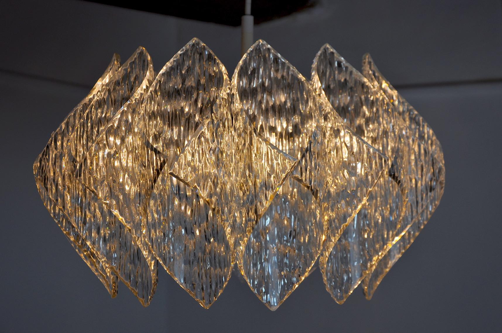 Très beau lustre de l'ère spatiale, conçu et produit en France dans les années 1970. Sa structure est composée de très belles plaques de bakélite à effet glace givrée. Objet design rare qui illuminera à merveille votre intérieur. Électricité