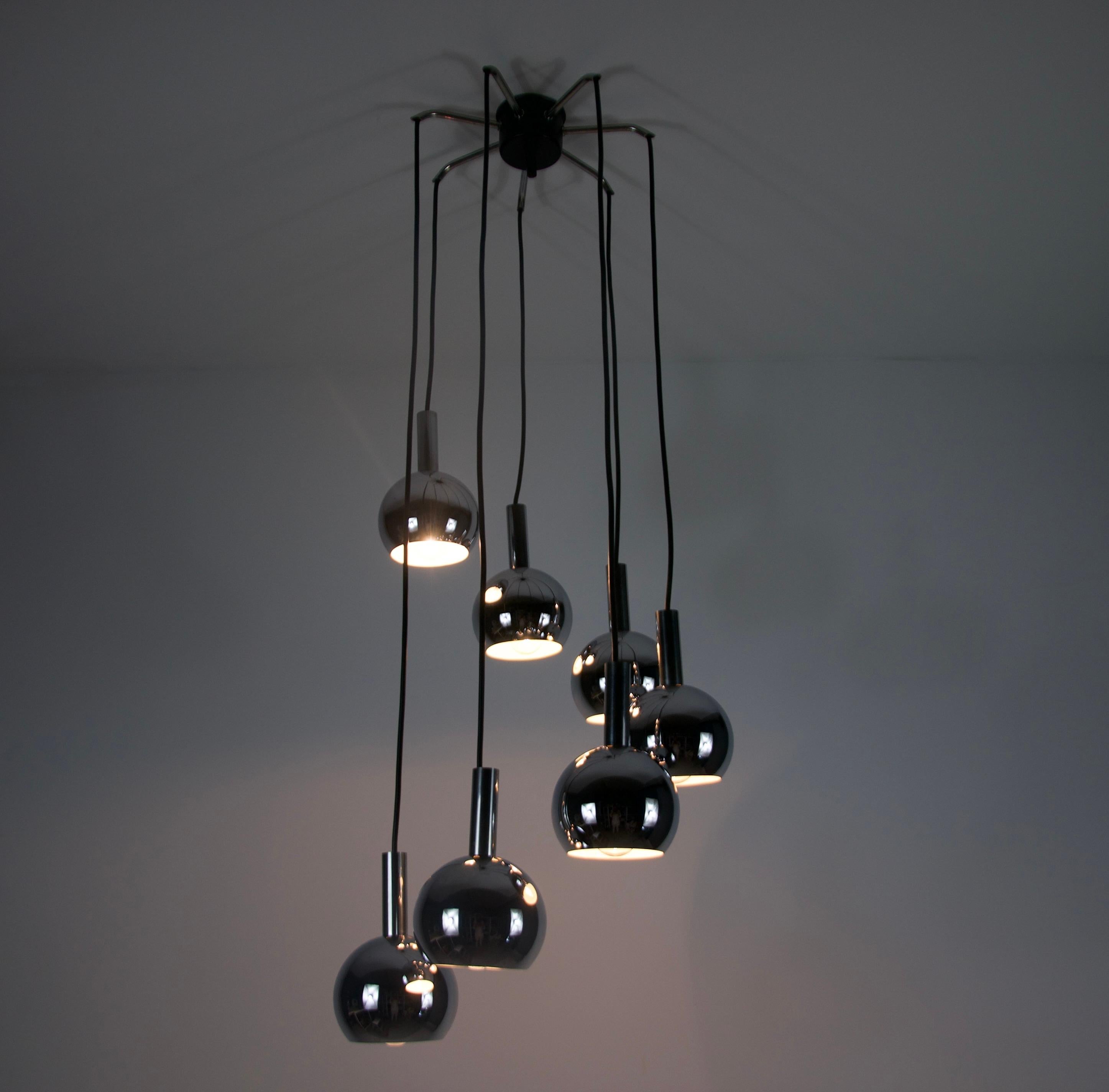 Stunning Space Age cascading ceiling lamp from the 1970s, featuring seven metal shades in a sleek, futuristic design. This iconic piece captures the essence of the Space Age era, with its clean geometric shapes and chrome metallic finish, evoking