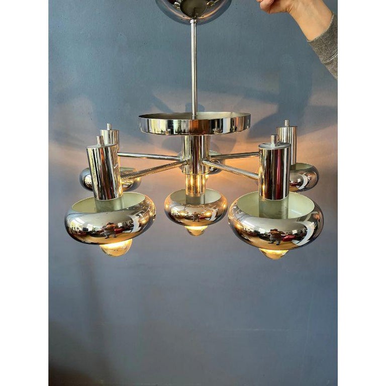 A very rare space age chandelier, designer unknown, reminds of Sciolari. The chandeliers consists of smaller shades/spots, each can be adjusted. The lamp is very heavy and therefore requires a proper mounting. The lamp requires six E27/26 (standard)