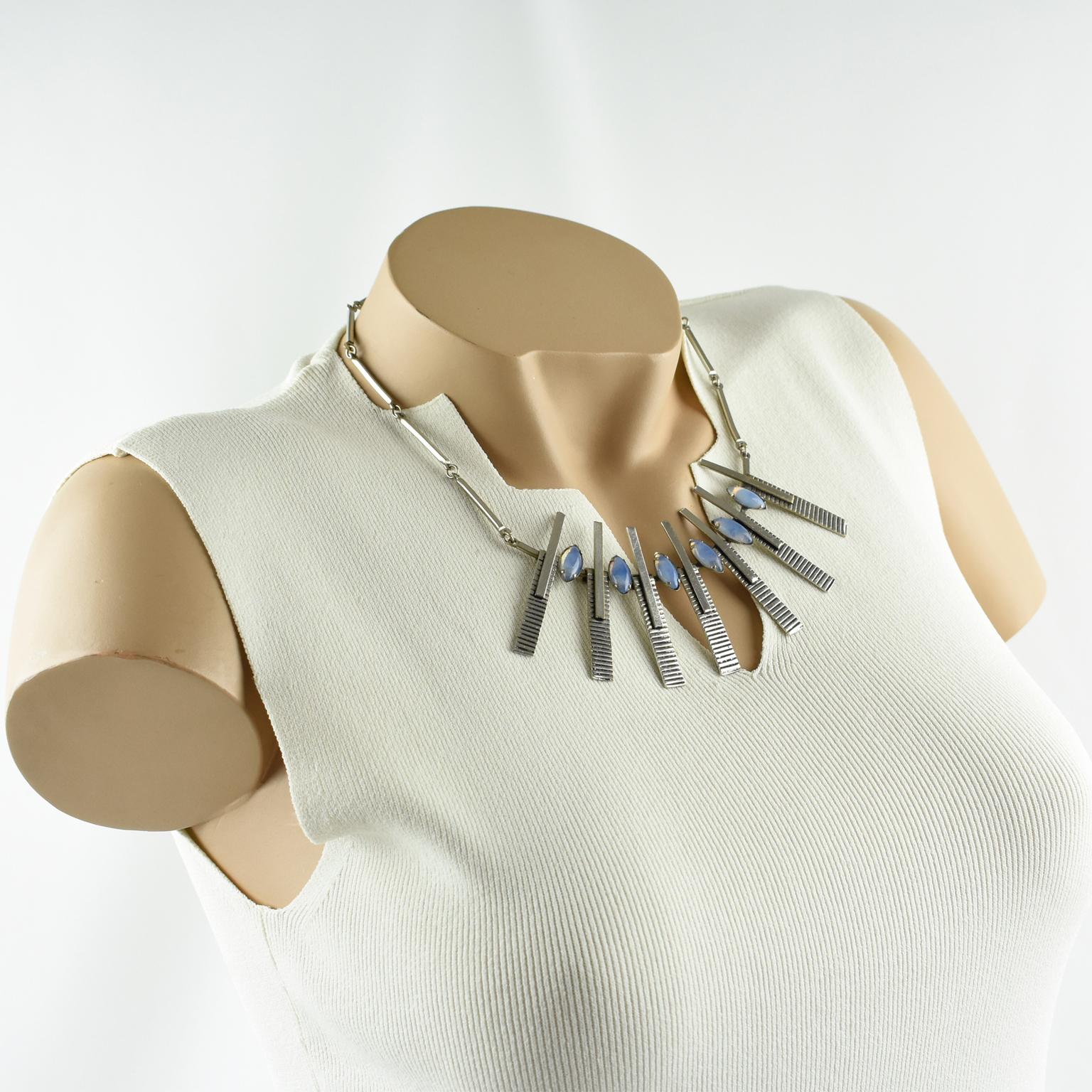 This stunning 1970s Space Age choker necklace has a modernist geometric central pendant. The necklace boasts a rigid chrome-plated metal chain adorned with a large central pendant and has a hook-closing clasp. The geometric is topped with oval