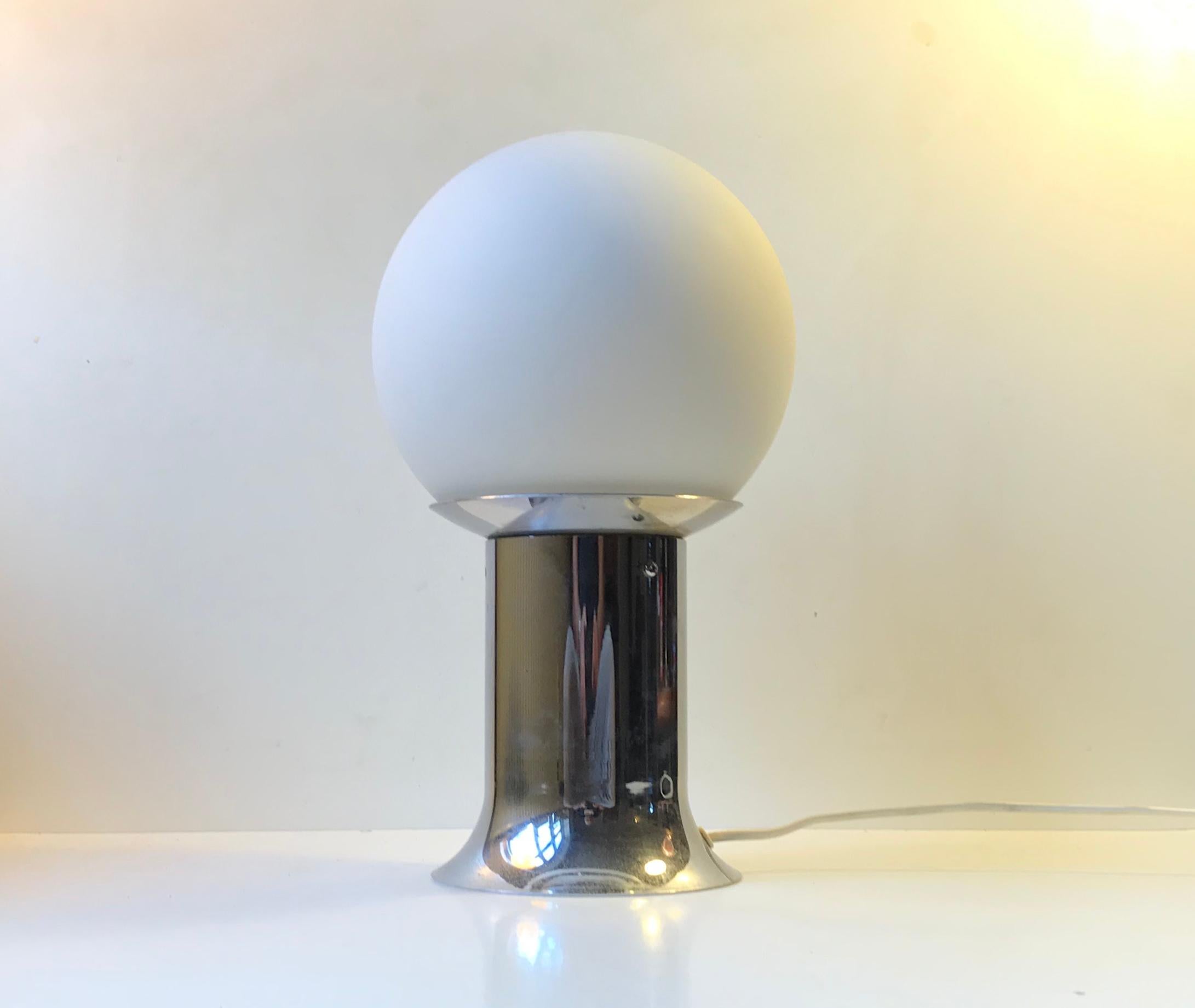 A Danish Space Age table light made of chromed aluminum and opaline glass. Manufactured by Lyfa in Denmark during the 1970s. It is very similar in design and constructions to designs from Gio Ponti, Verner Panton and Fontana Arte.