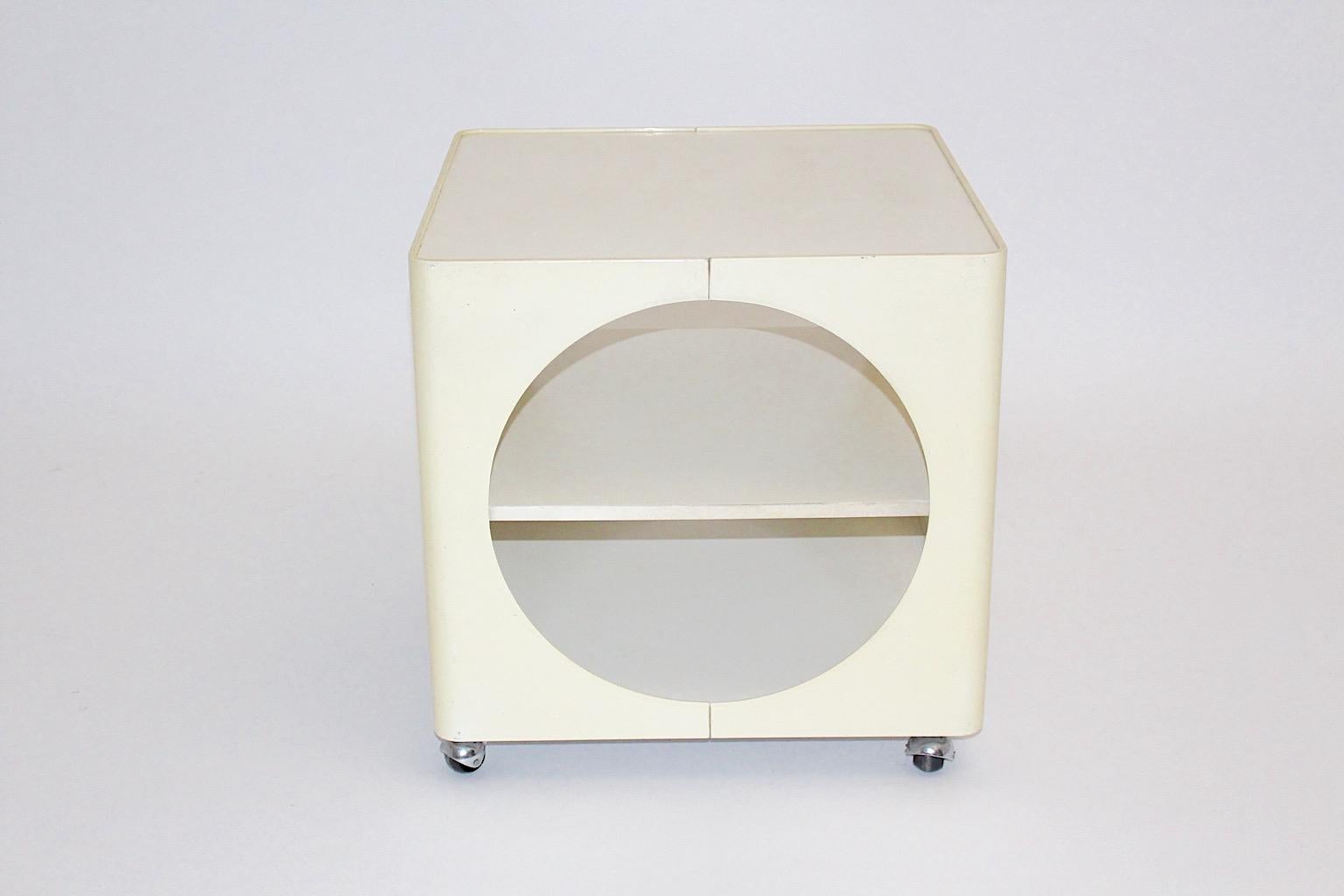 Space Age butter cream white ivory vintage cube bar cart or side table from plastic designed 1960s Germany.
The vintage bar cart or side table shows 4 wheels for good mobility and one shelf.
In the space age time the designer loved to play with