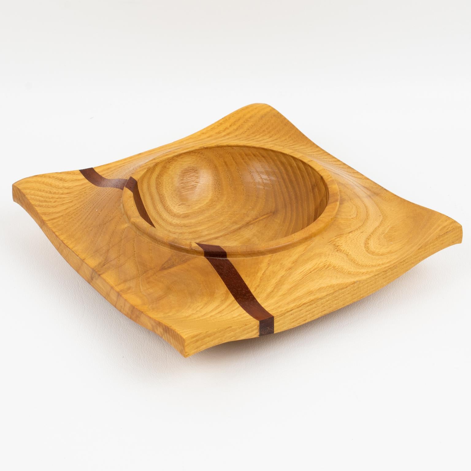 This exquisite modernist Space Age Danish carved bowl, catchall, or desk accessory boasts lovely wood marquetry. This vide poche has a geometric wavy shape with a typical spatial ship design with different woods in fine grain and mixing tropical