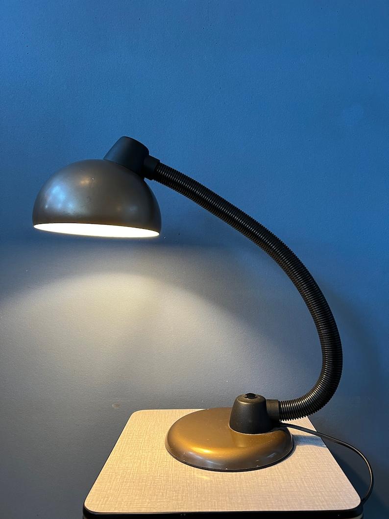 Space age table lamp with easily adjustable arm and shade. The black arm allows you to position the lamp in any way desirable. The lamp requires one E27/26 (standard) lightbulb and currently has an EU-plug.

Additional information:
Materials: Metal,