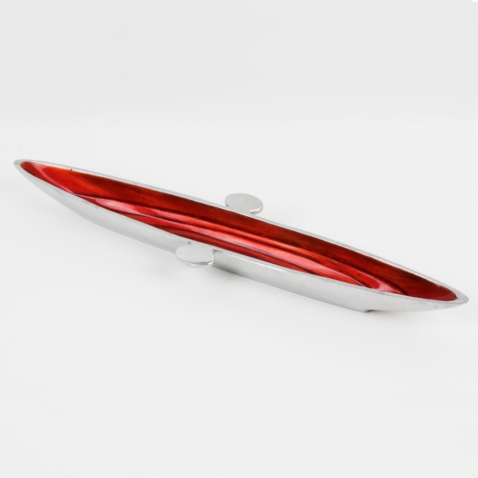 This striking modernist Space Age aluminum bowl, vide poche, was crafted in the mid-20th century in France. The elongated canoe-shaped piece has a typical spatial ship design. The catchall is made of polished cast aluminum with a bright red-orange