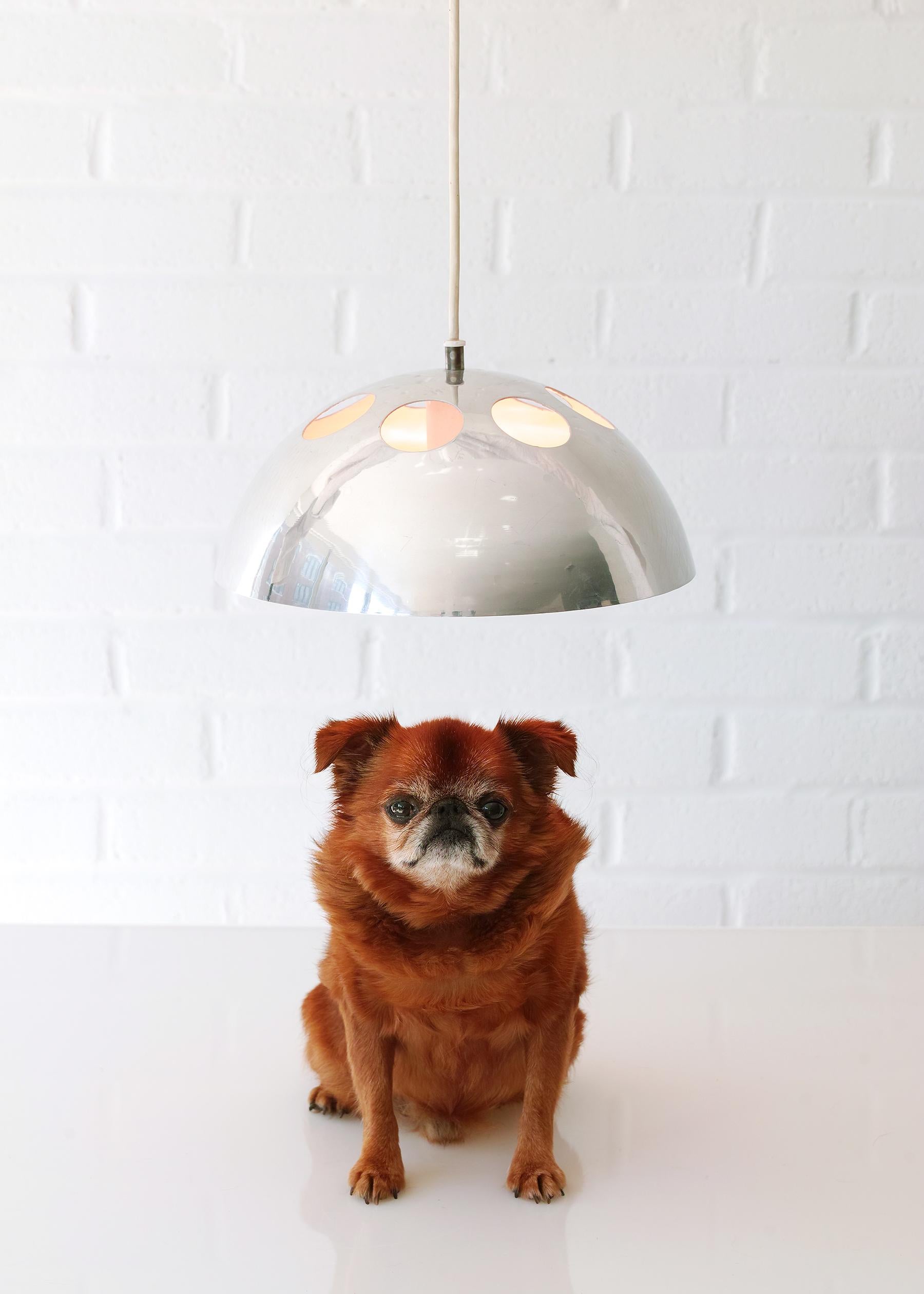 For your consideration is this all-original Space Age dome pendant light featuring spun aluminum construction with outer chrome finish and inner ivory white finish. Distinctive are the seven circular cutouts on the upper portion of the dome which