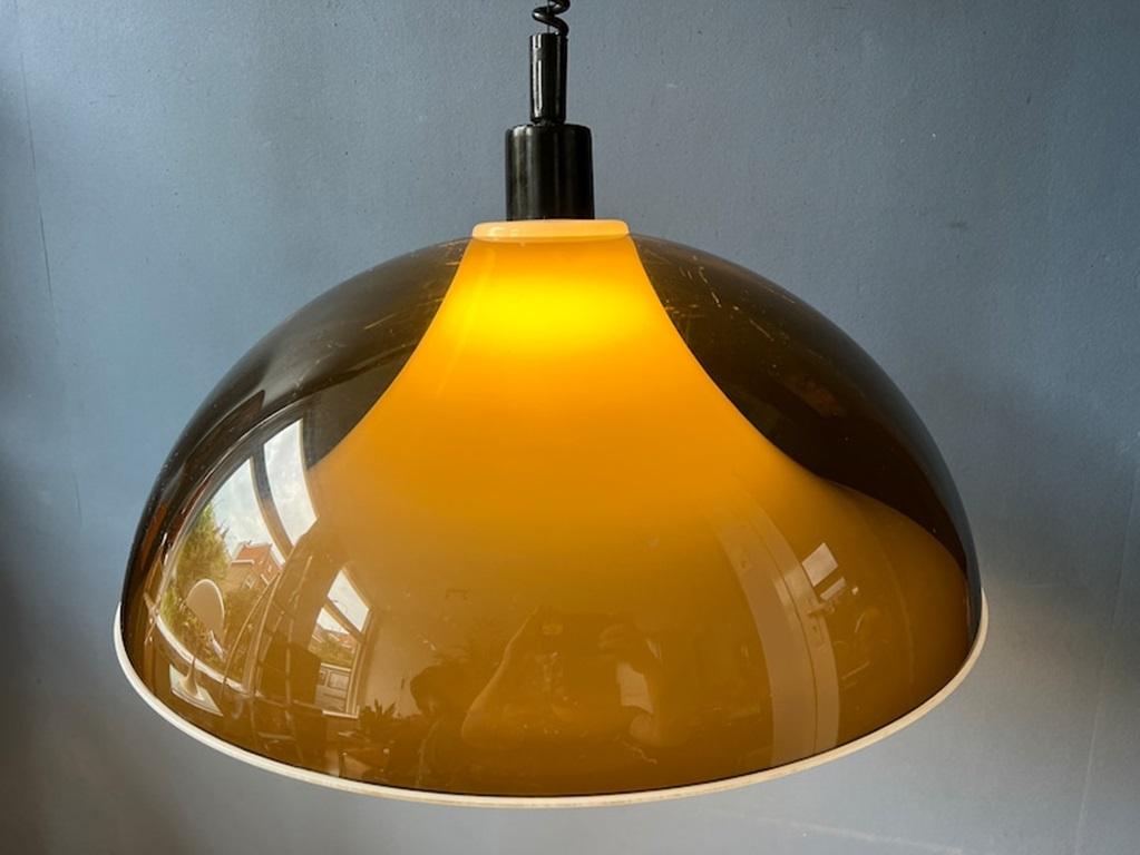Very rare space age pendant lamp by Elio Martinelli for Artimeta with a double smoked acrylic glass shade. The outer shade is transparent and has a dark, copper-like colour, the inner shade is white. Together they create an astonishing light effect.