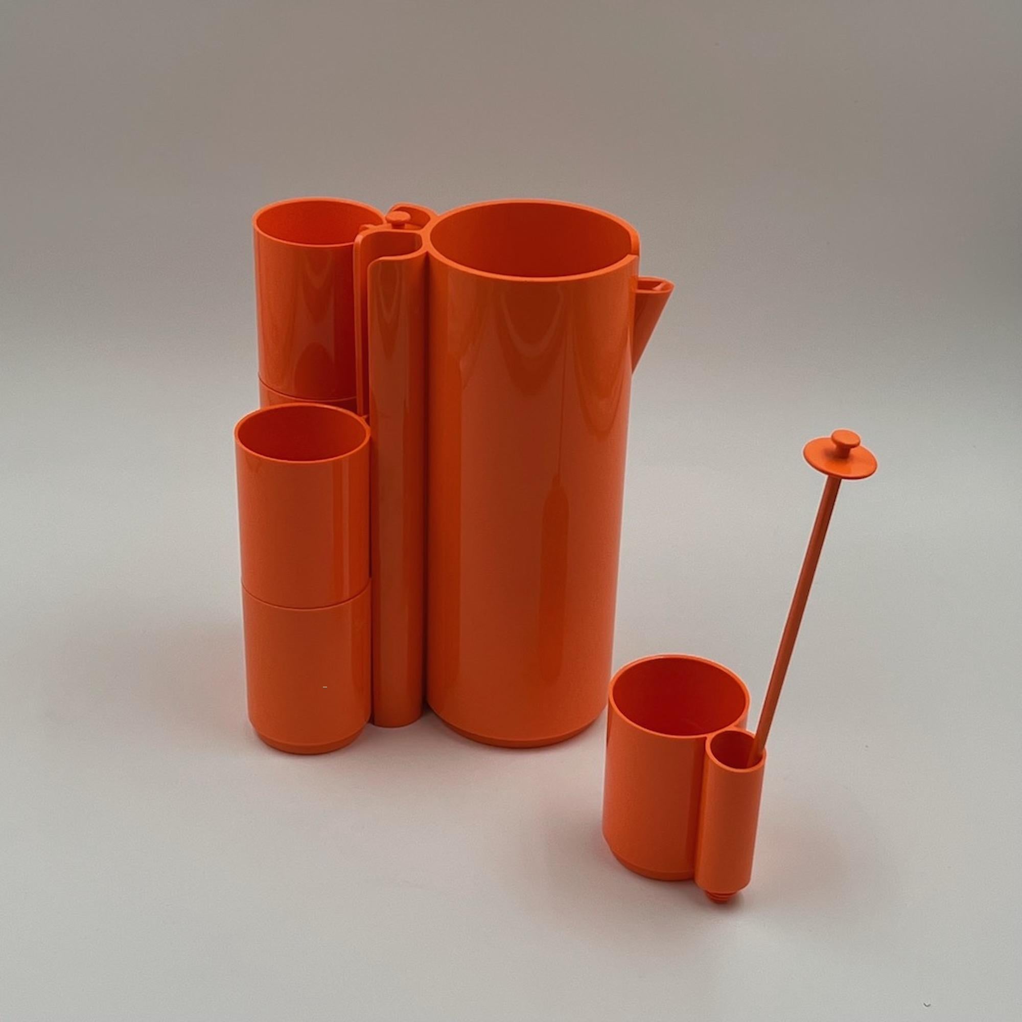 Vintage 'Orangeade' 1970s drinking set designed by Jean Pierre Vitrac in a vibrant orange color.  This beautiful set includes six plastic cups and a matching jug for all types of refreshing beverages.  This practical set is ingeniously designed with