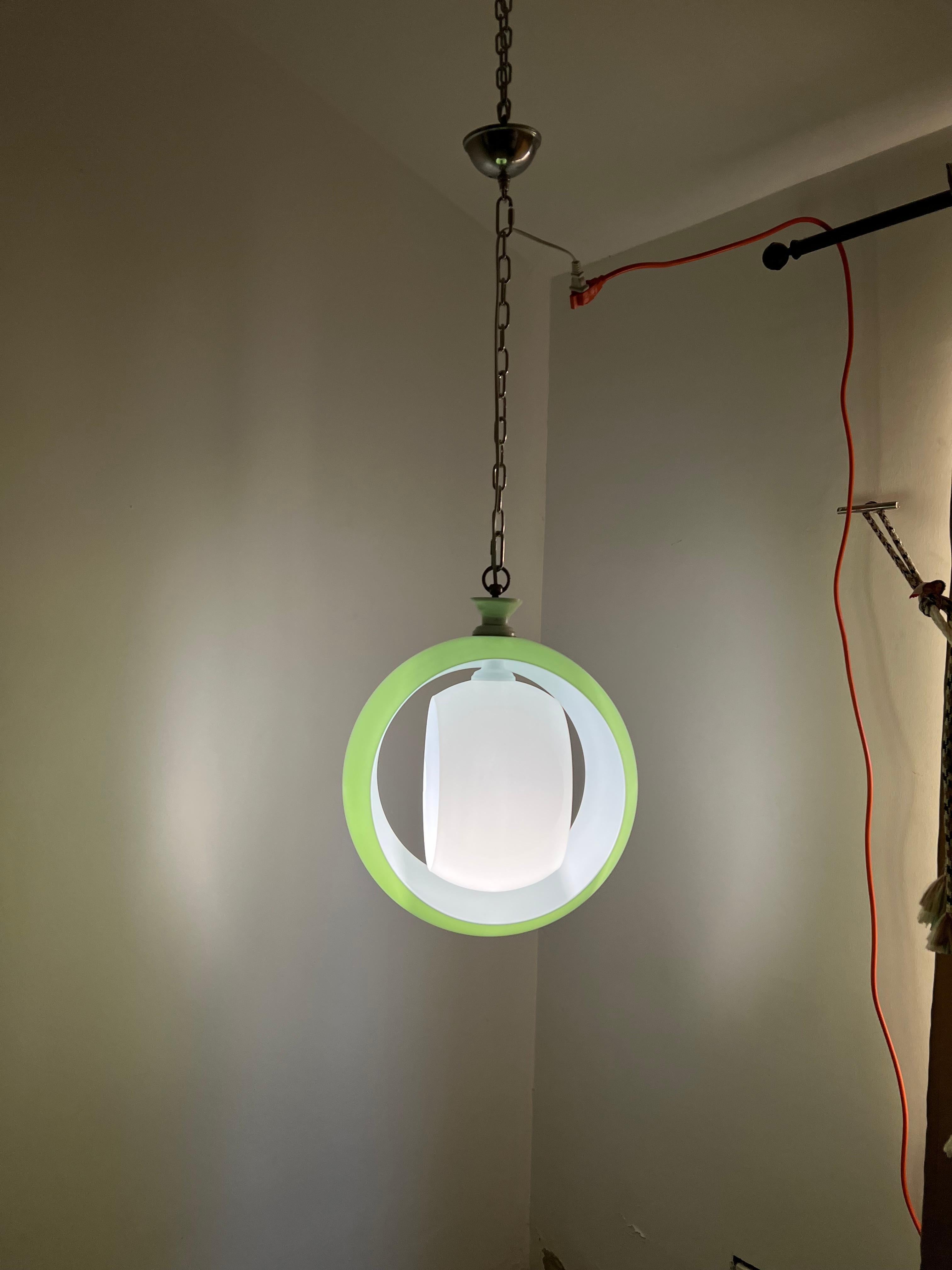 Space age chandelier manufactured in green and white incamiciato Murano glass. Two concentric circles that can be rotated as to simulate a light 