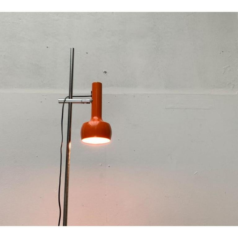 Minimalist floor lamp from Swisslamps International in a special color.

A simple and reserved design in orange and chrome. The light head
Shows a radiator shape with a striking screen. It can be adjusted at the shaft in height and aligned