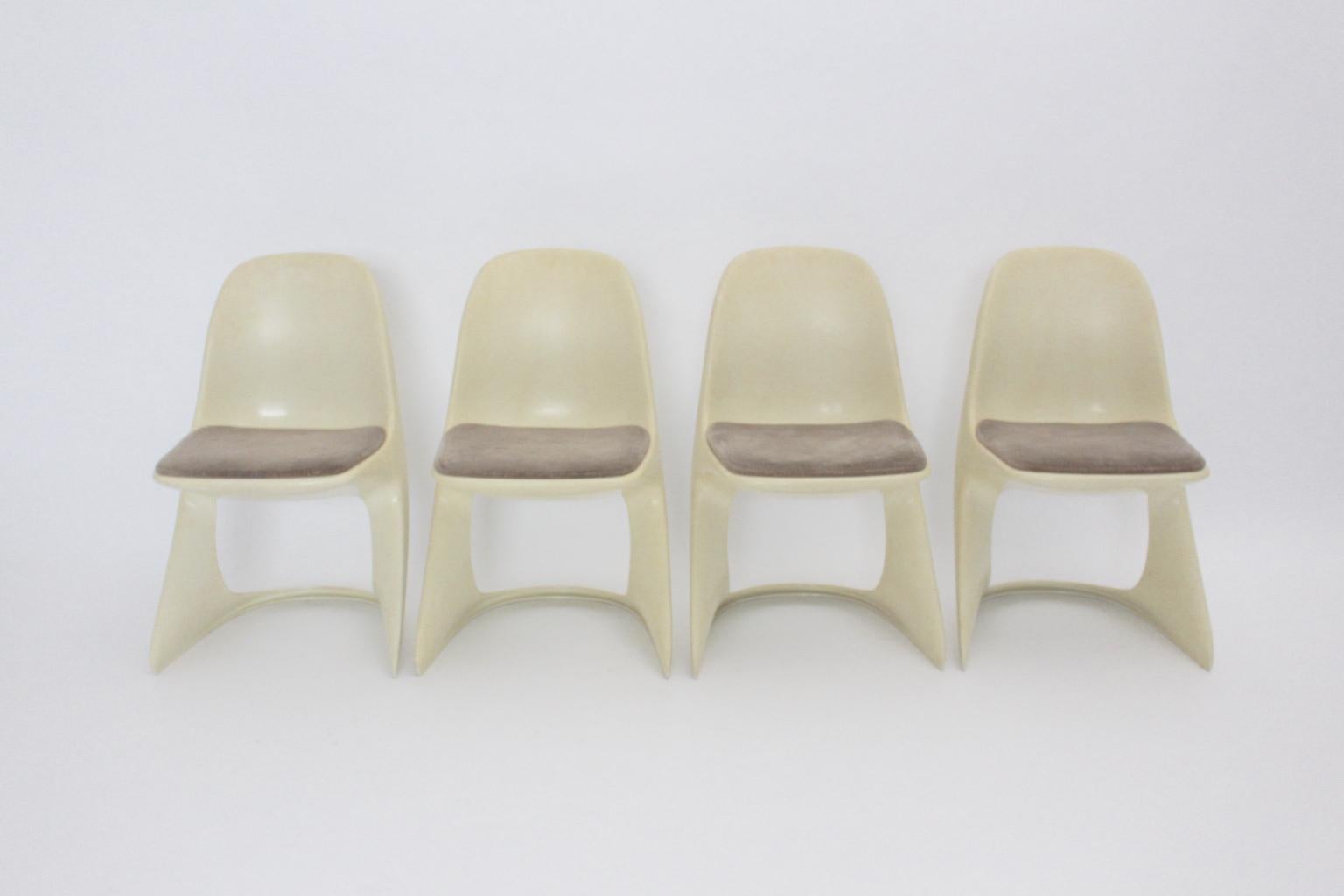Space Age set of four vintage dining chairs named Casalino by Alexander Begge, Germany, 1971 for Casala, Germany was made of  cream white plastic. Also the dining chairs feature upholstered seats covered with brown velvet fabric.
The vintage