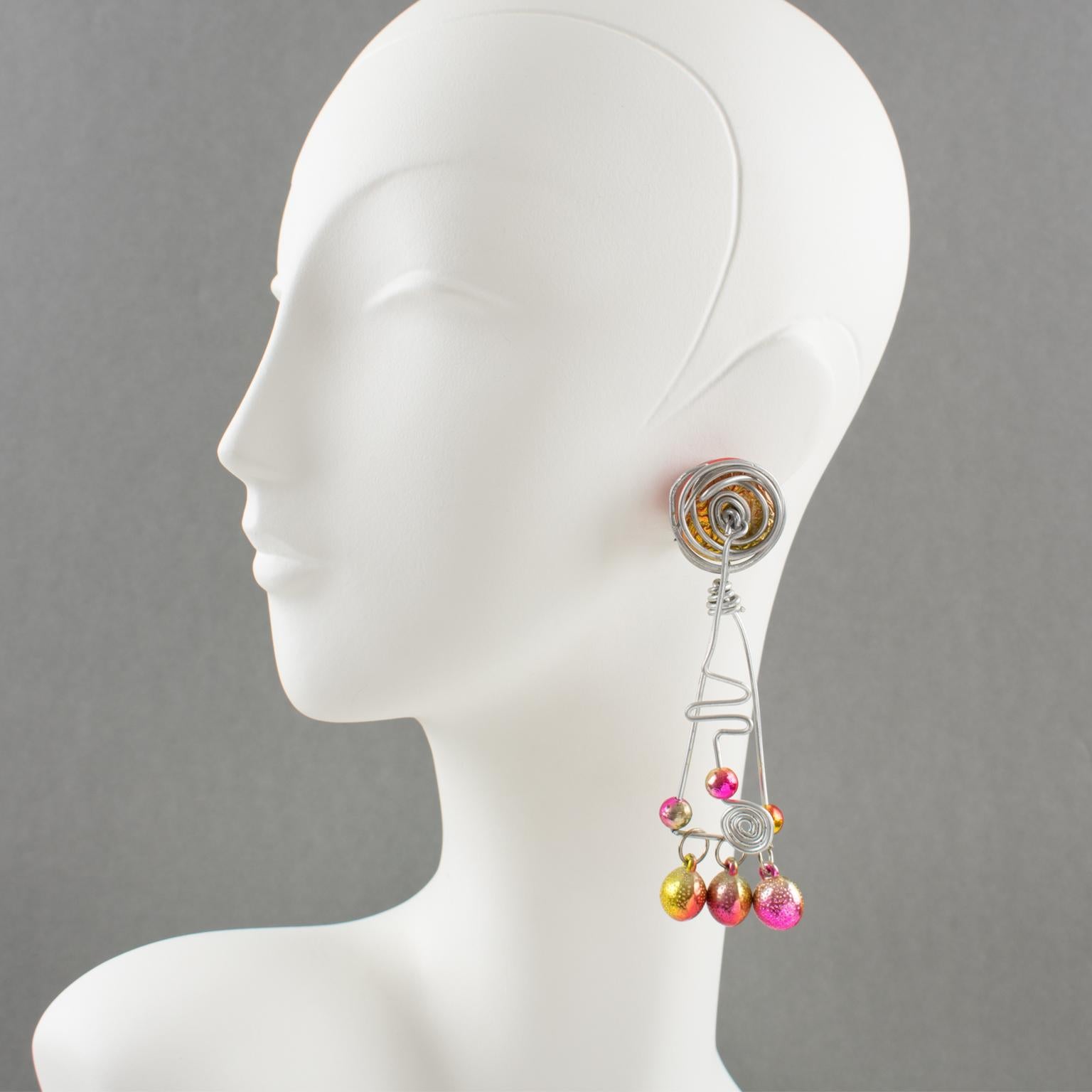 Those impressive 1990s Space Age oversized aluminum dangling clip-on earrings feature a stunning hand-made futuristic design with a dangle articulated spiral coil and geometric elements along with assorted size beads. The iridescent hot pink and