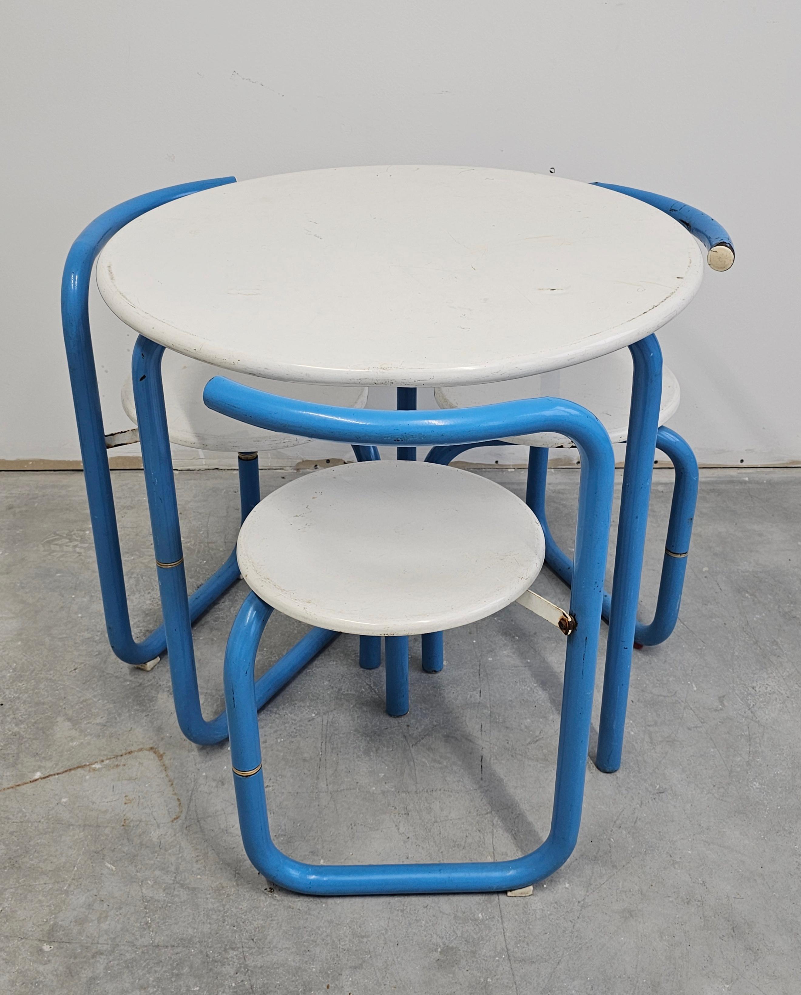 In this listing you will find a stunning Space Age patio, garden and dining room set, consisting out of a folding table and 3 folding chairs with distinctive design. They are all done in white and blue metal, with curved legs and backrests. Made in