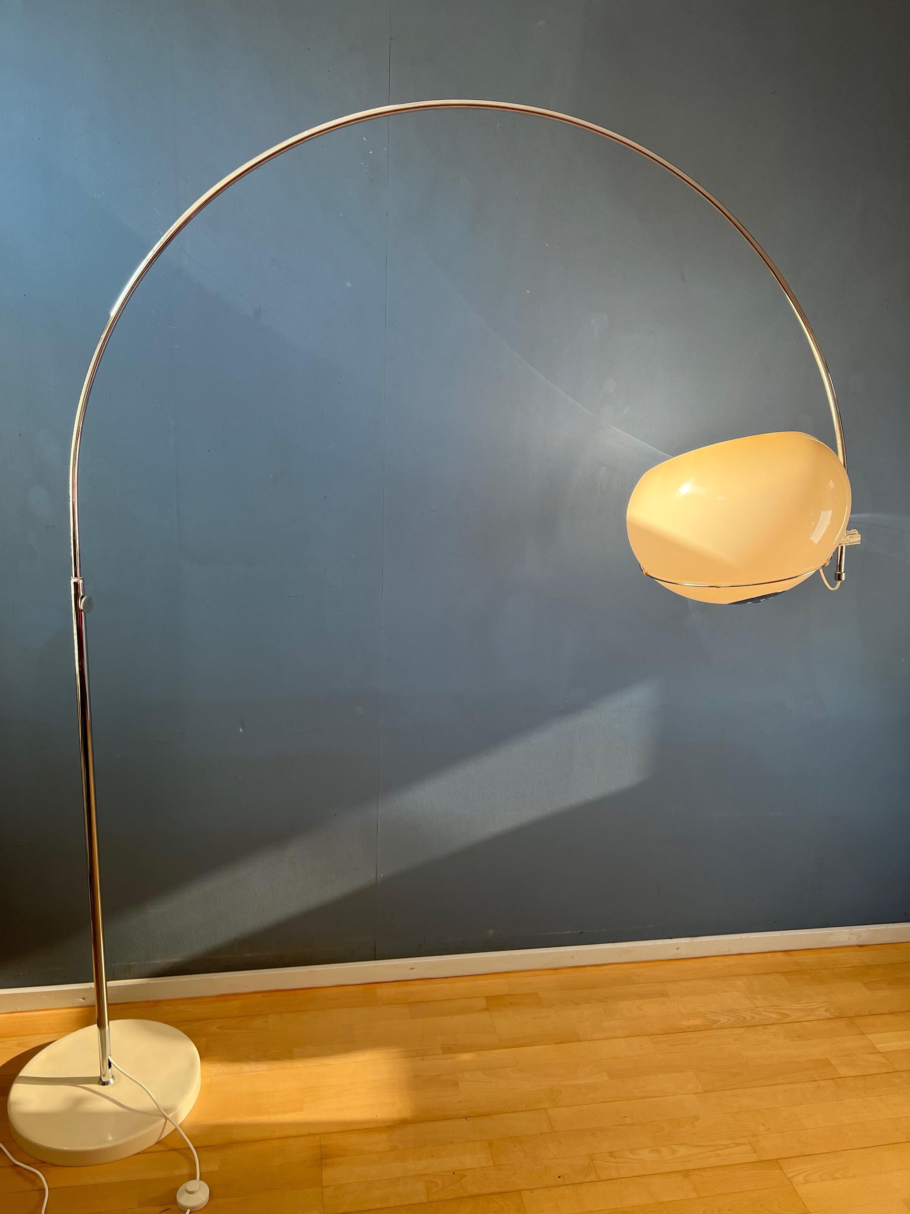 This GEPO arc floor lamp has an acrylic shade that produces a moon-like glow. It has a chrome frame that is an excellent, shiny condition and a beige base that has a delicate beige paint. The 'mushroom' shade can be placed in the metal ring in any