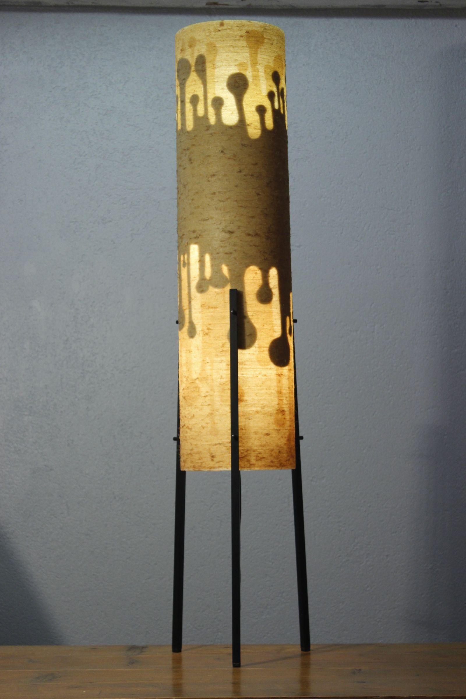 German floor lamp circa 1960, consisting of a resin cylinder decorated on the inside with stickers giving a beautiful transparent pattern when lit, resting on three painted steel feet. 

In good condition, with a small dent in the top of the