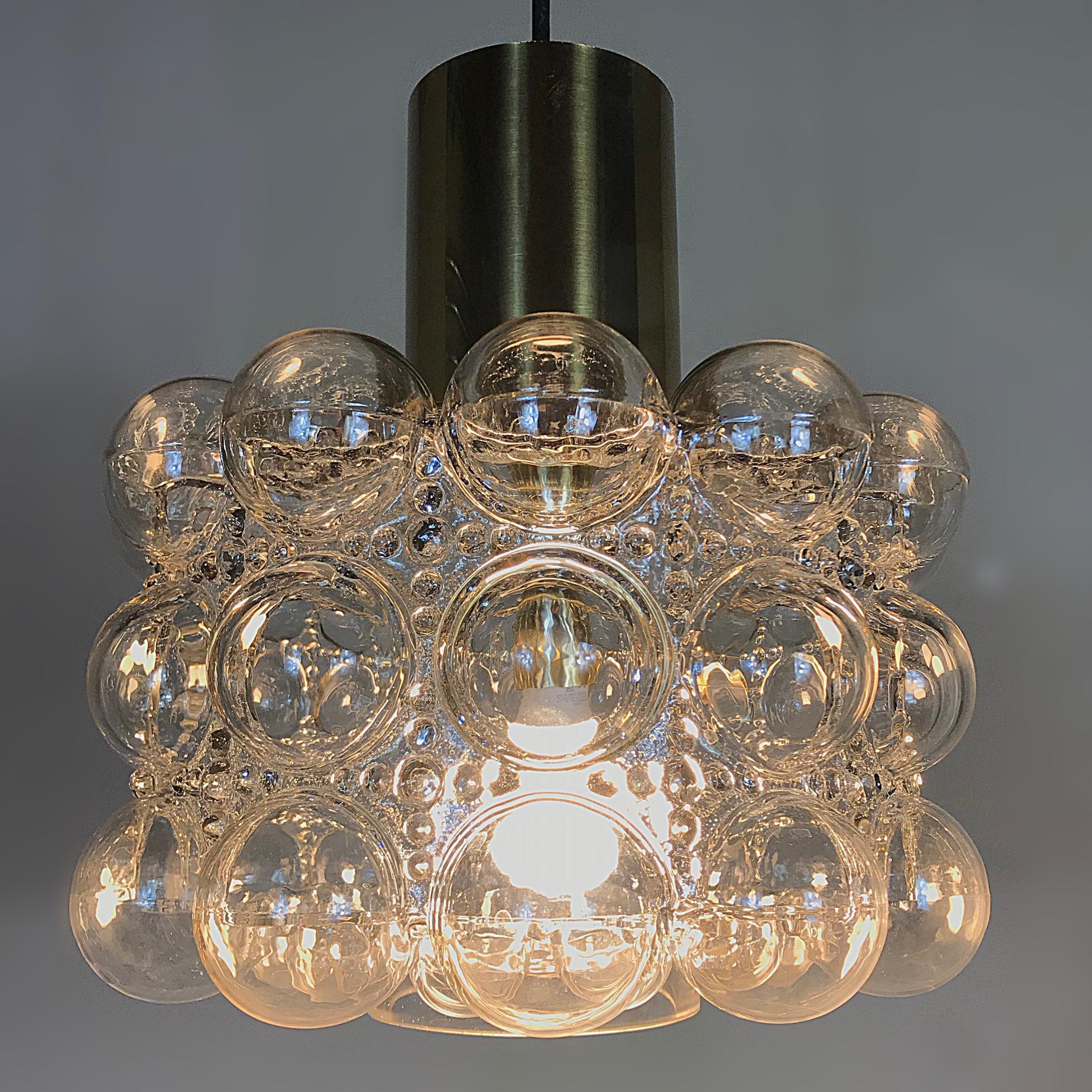 Beautiful Space Age bubble clear glass pendant lamp manufactured by Glashütte Limburg, with the characteristic blown glass designed by Helena Tynell. This lamp is a striking appearance in any room. Due to the sublime combination of glass and brass,