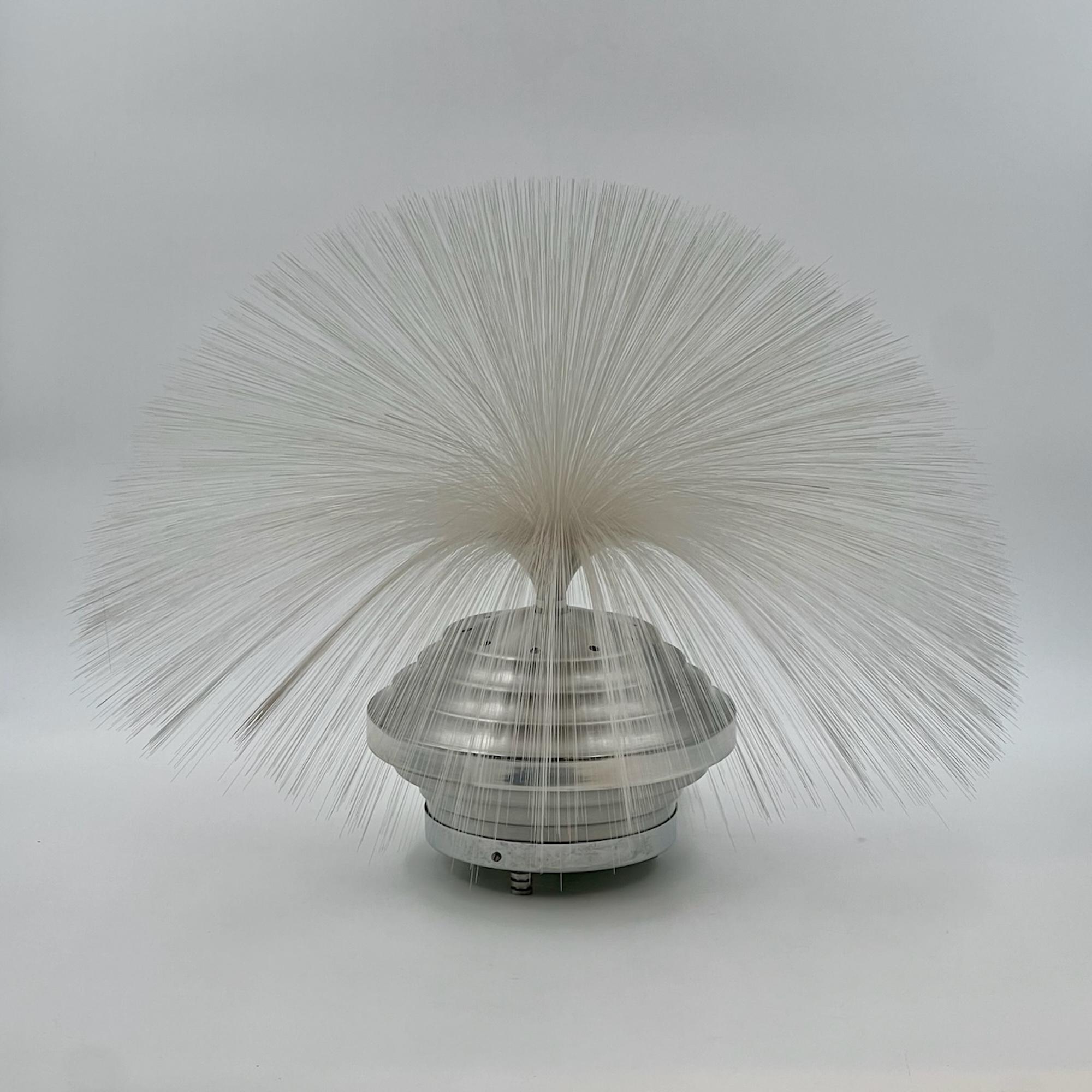 Transform your space with this vintage Space Age lamp, a true masterpiece of 70s design. The lamp features an ingenious rotating plastic disc with eight vibrant colors, casting a hypnotic effect on the multicolor “fountain of light” that surmounts