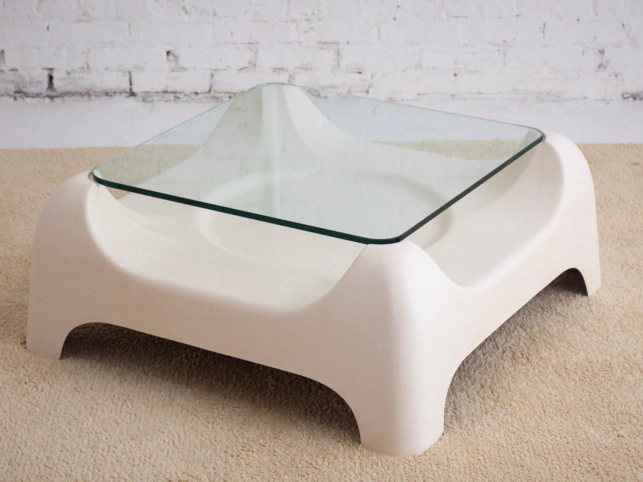 Une table basse italienne en fibre de verre de l'ère spatiale avec un plateau en verre. La base sculpturale en fibre de verre moulée soutient le plateau supérieur en verre. Finition blanc cassé semi-brillant. Provenant du nord de l'Italie.