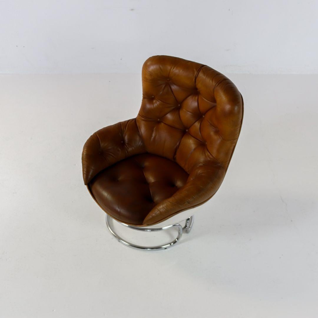 Beautiful Space Age armchair from the 1960s by Michel Cadestin for Airborne France. White fiberglass glossy shell with chromed metal base and cognac leather upholstery. The shell is in very good condition, the frame shows slight signs of use, and