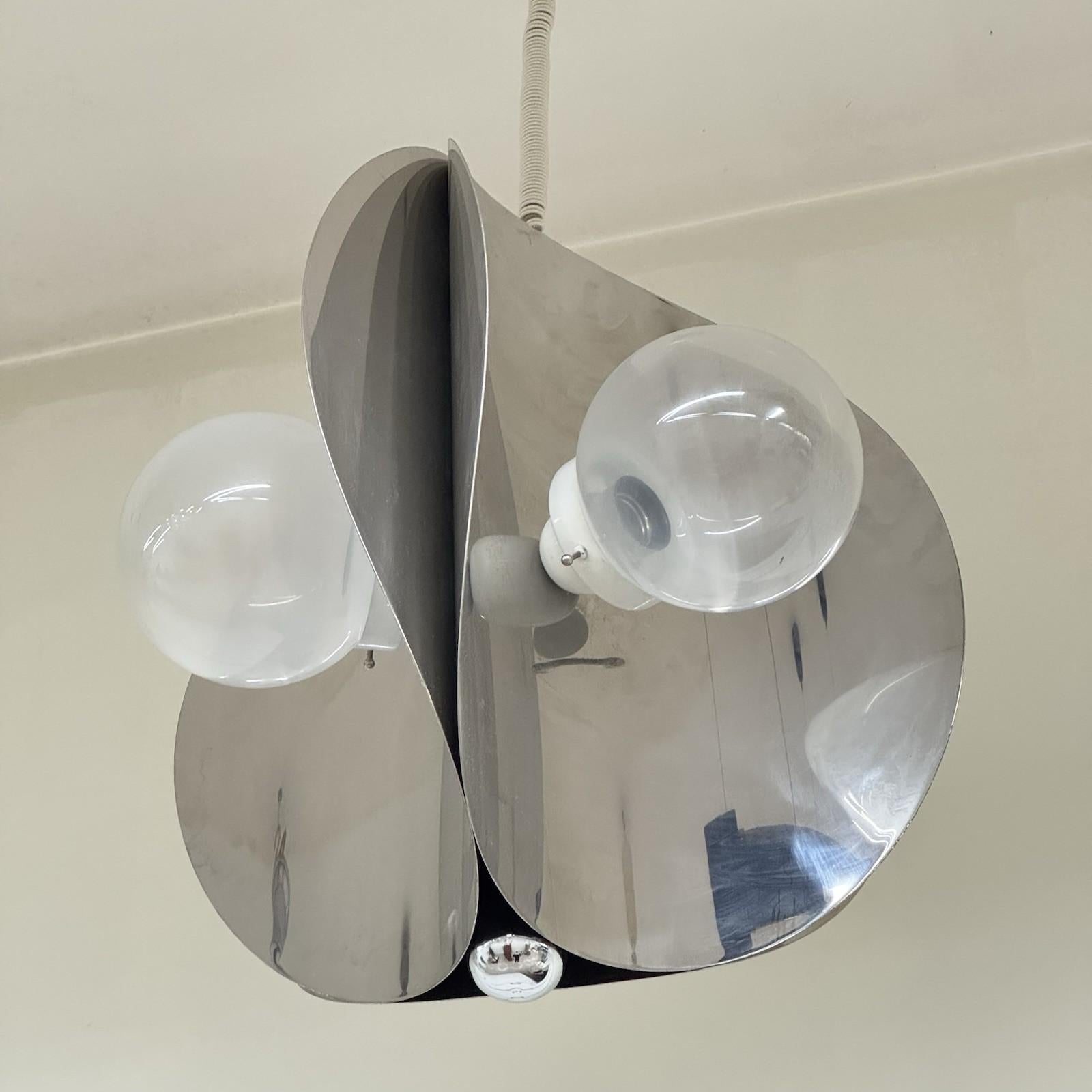 Lampada A Space A Sospensione Design Modernariato 1970.

Struttura interamente in acciaio cromato a onde, diffusori in vetro opalescente.

L'articolo è in ottime condizioni conservative, non vi è alcun difetto estetico o strutturale da segnalare,