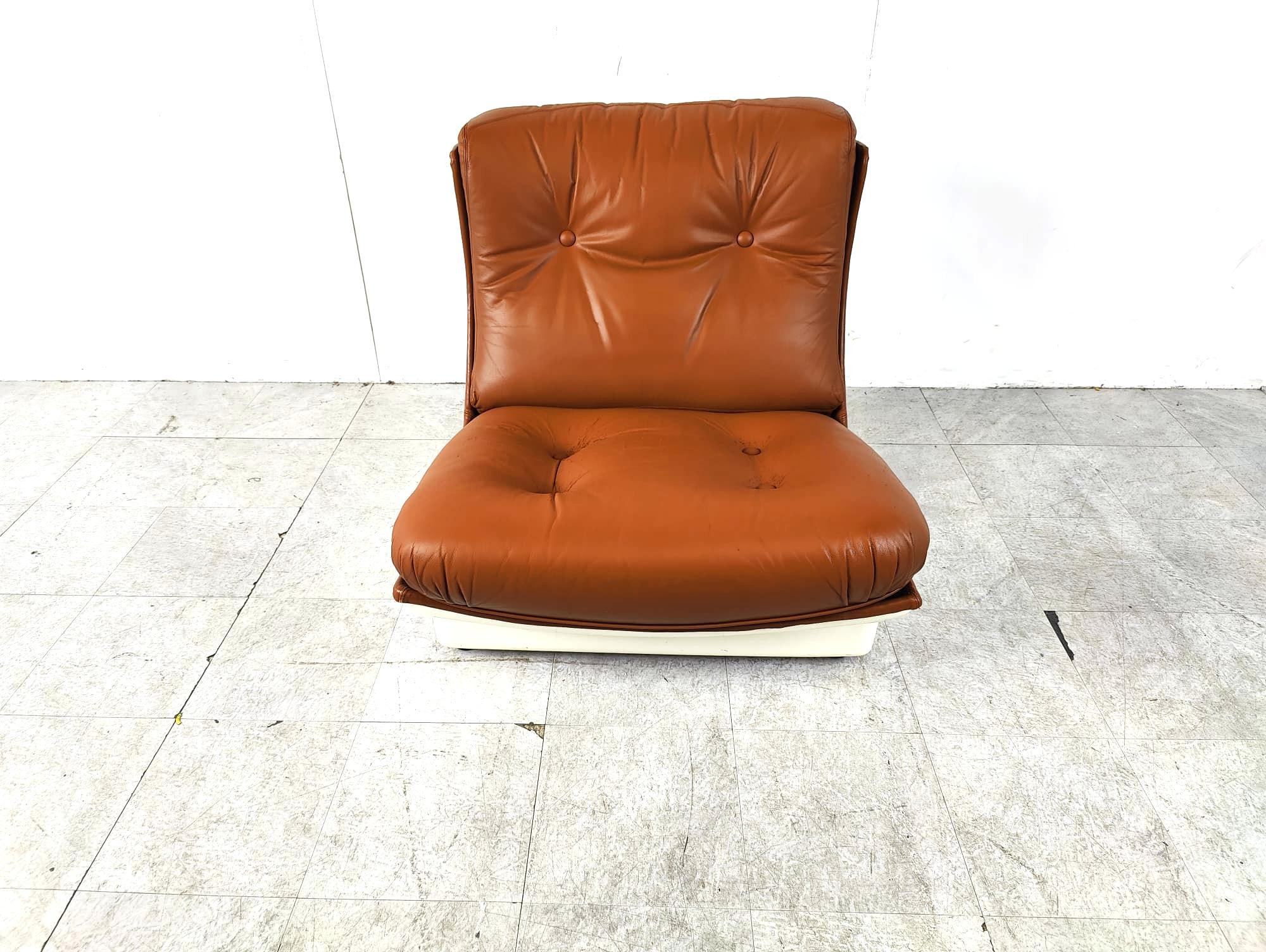 Striking space age lounge chair by Airborne international.

The chair consists of a white fiberglass shell upholstered with brown butonned leather.

It sits as comfortable as it looks.

Good condition, original upholstery with patina, no