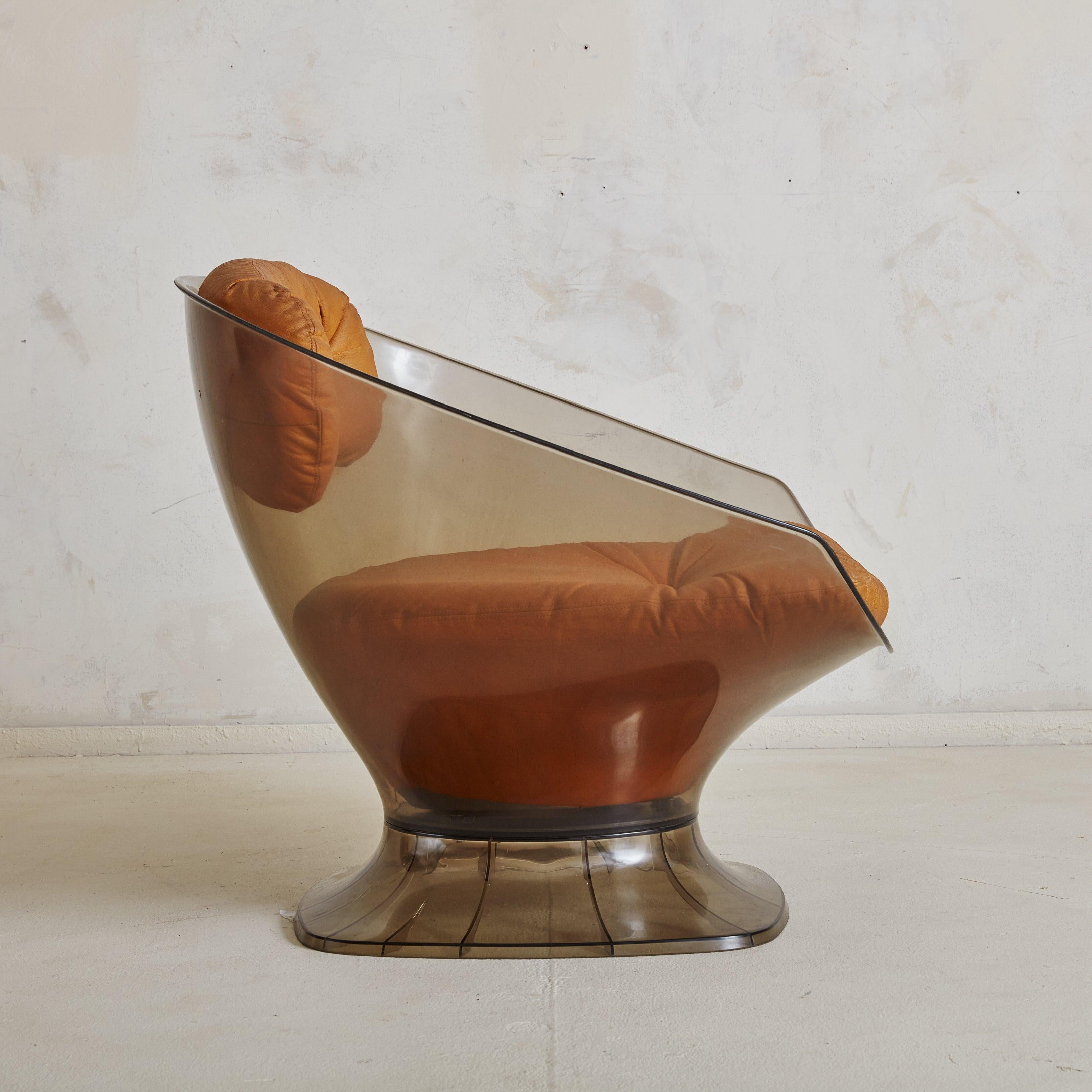 Una rara tumbona de la Era Espacial de los años 60, obra del diseñador francés Raphaël Raffel. Esta silla modernista presenta una carcasa moldeada de acrílico ahumado que acuna con gracia el cuerpo. Su rica tapicería de cuero original de color