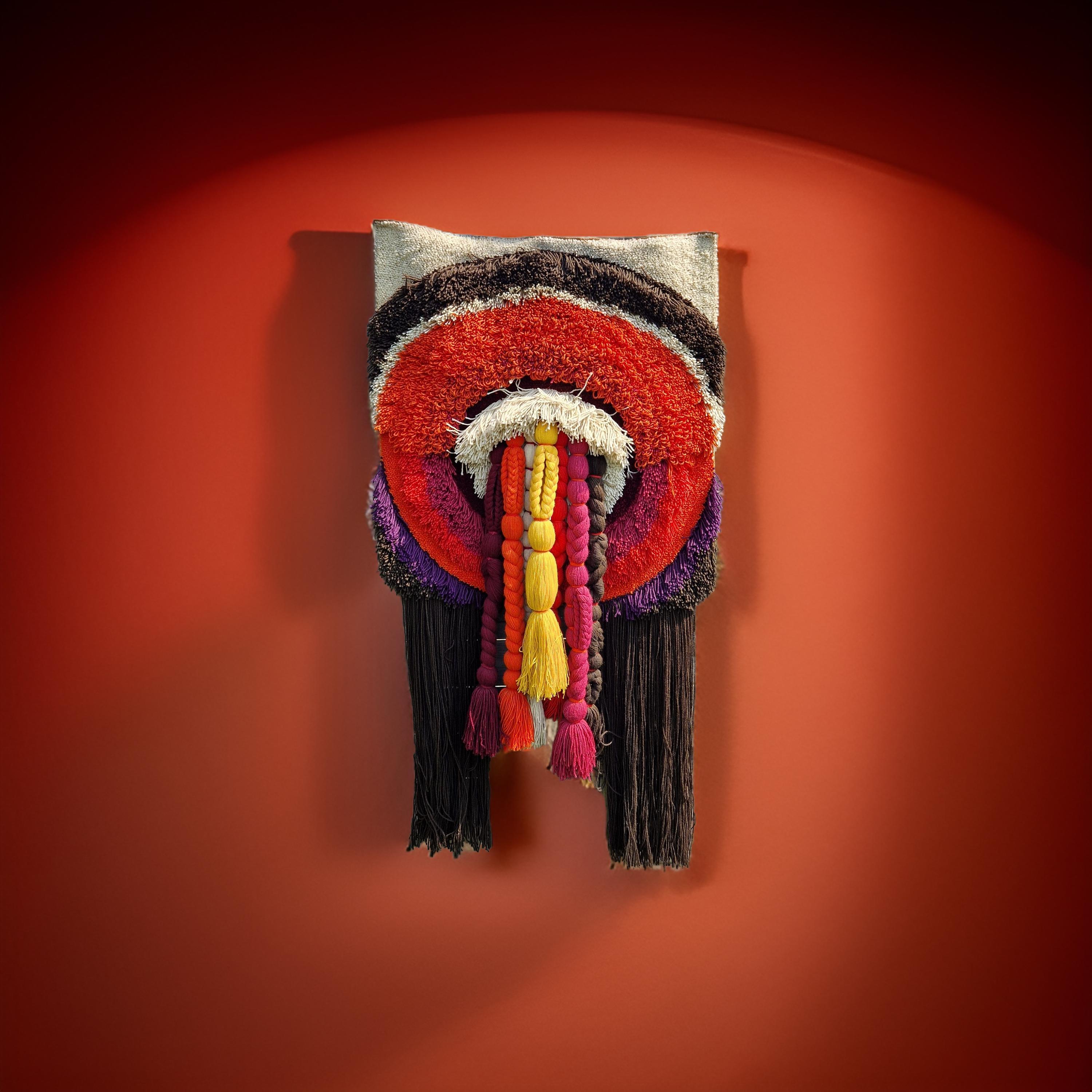 Colorido colgante de pared de la era espacial. Tejido a mano con hilo de lana. Tiene largas trenzas de distintos colores que salen del centro. Los colores siguen siendo brillantes y la alfombra está en muy buen estado teniendo en cuenta la edad. Aún