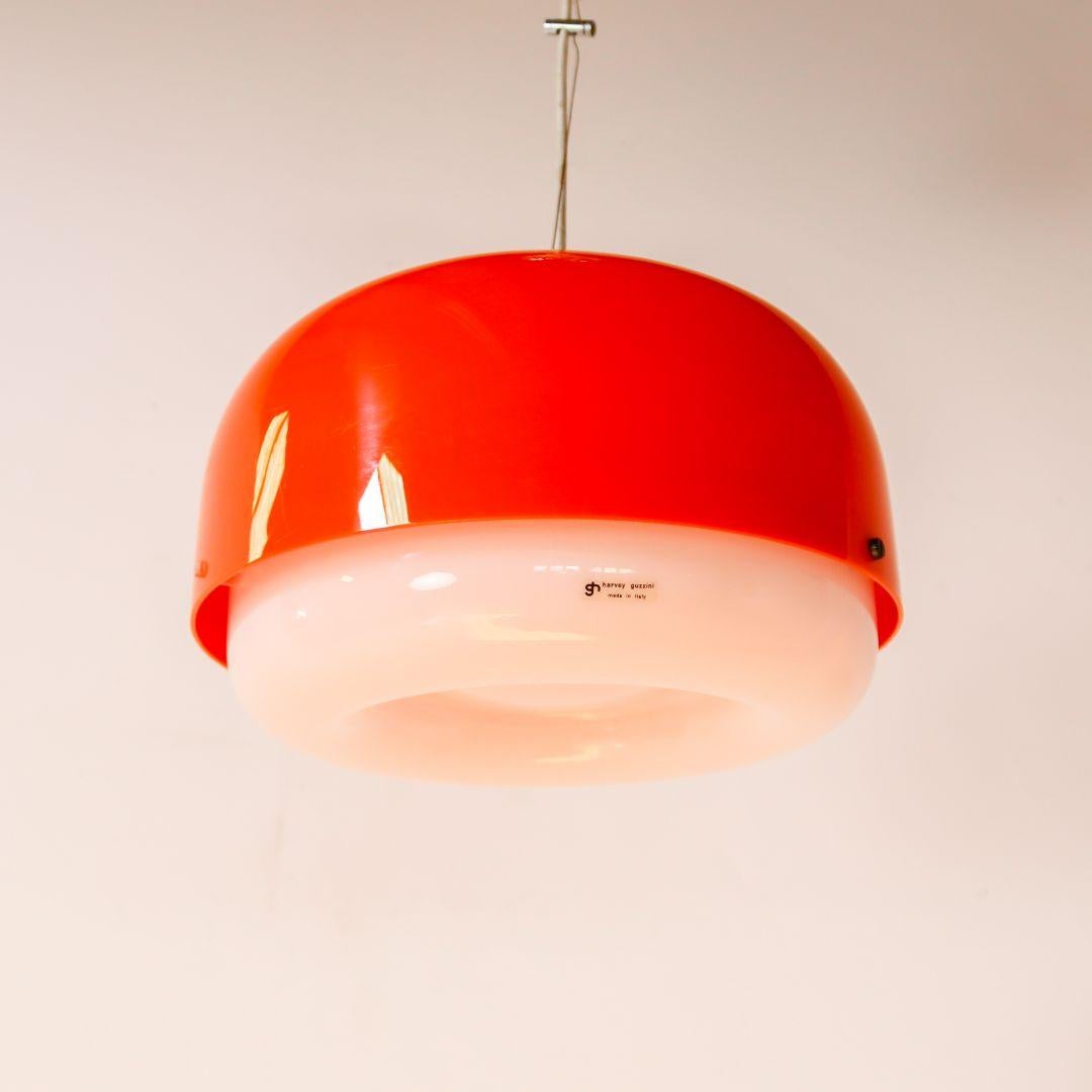 Italian 1970s Space Age pendant lamp by Luigi Massoni for Harvey Guzzini. With an orange/white plastic shade. The lamp is in good vintage condition with minor signs of wear.