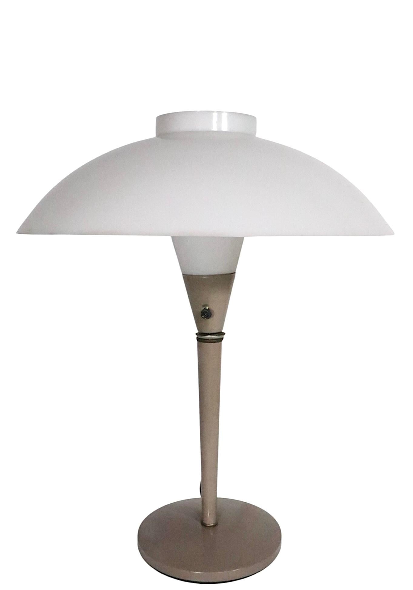 Classique du milieu du siècle et de l'âge de l'espace, conçu par Gerald Thurston, pour Lightolier, vers les années 1970. La lampe se compose d'un abat-jour en forme de soucoupe et de dôme en plastique blanc, monté sur un mât vertical effilé. La